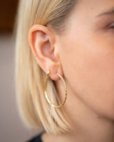 Pave Diamond Hoop Earrings and Huggie Gold Solid Snack Hoop Earrings on model.