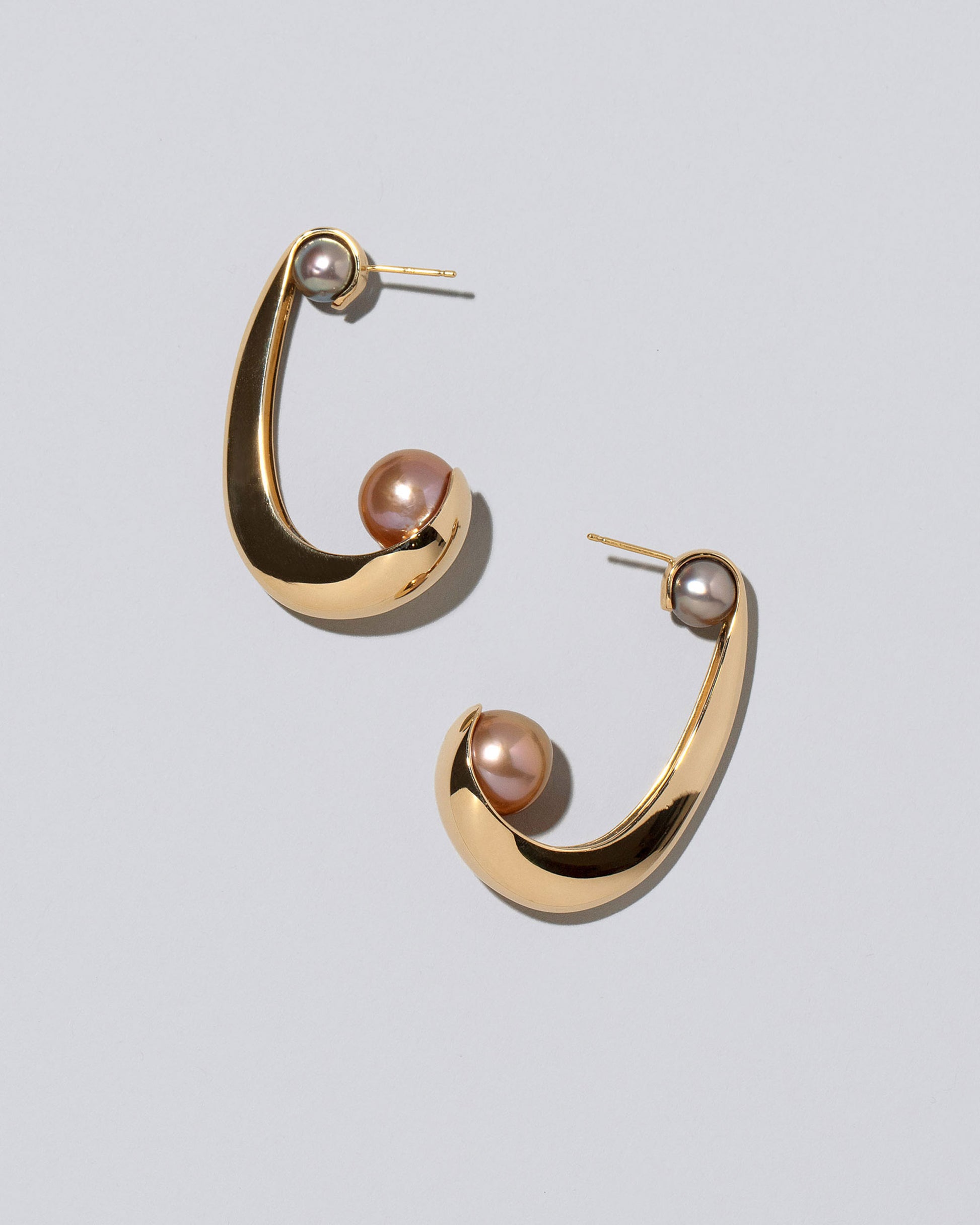 Closeup detail of the Pearl Hoop Earrings on light color background.
