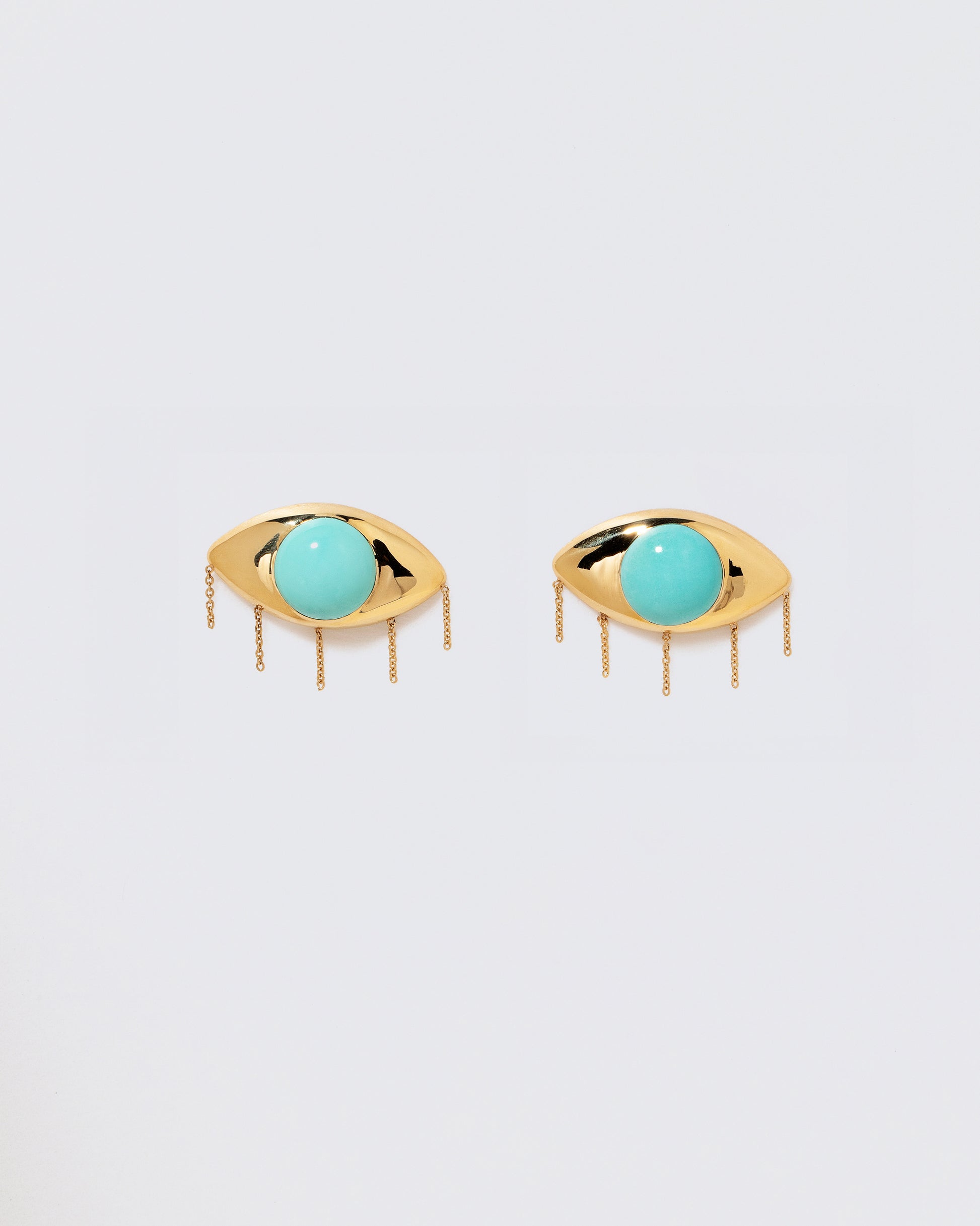 Turquoise Eye Earrings on light color background.
