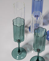 Closeup details of a group of Fazeek Clear, Blue and Teal Wave Flute Sets on light color background.