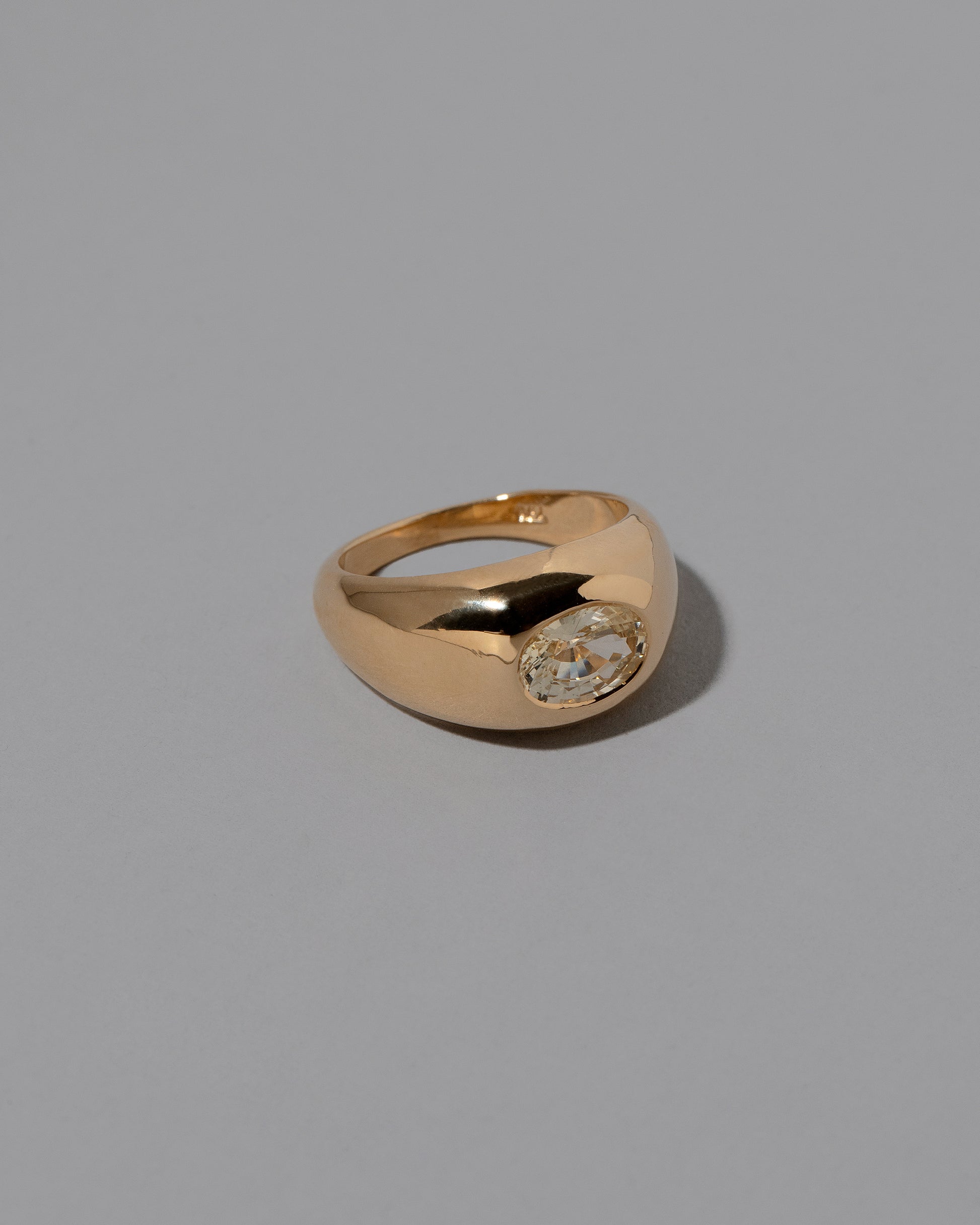 View from the side of the Yellow Sapphire Jupiter Ring on light color background.