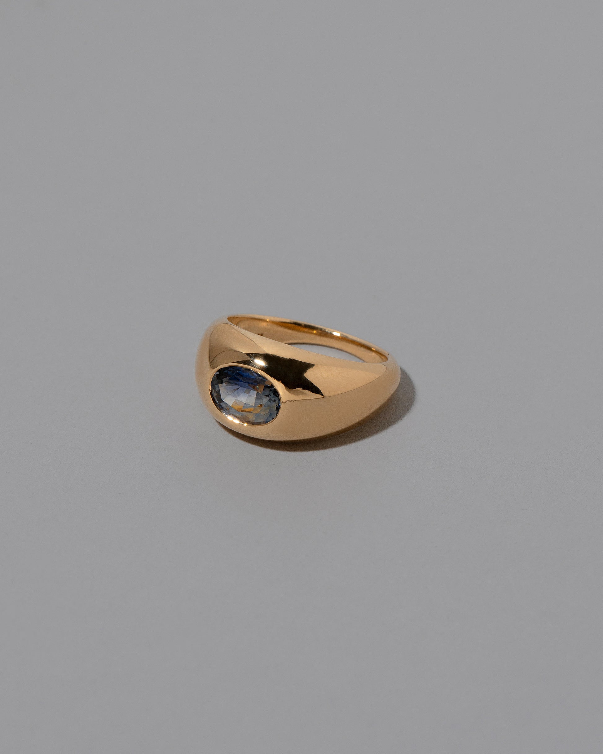 View from the side of the Bicolor Sapphire Jupiter Ring on light color background.