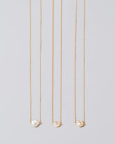 Group of the White Lagniappe Pearl Necklaces on light color background.