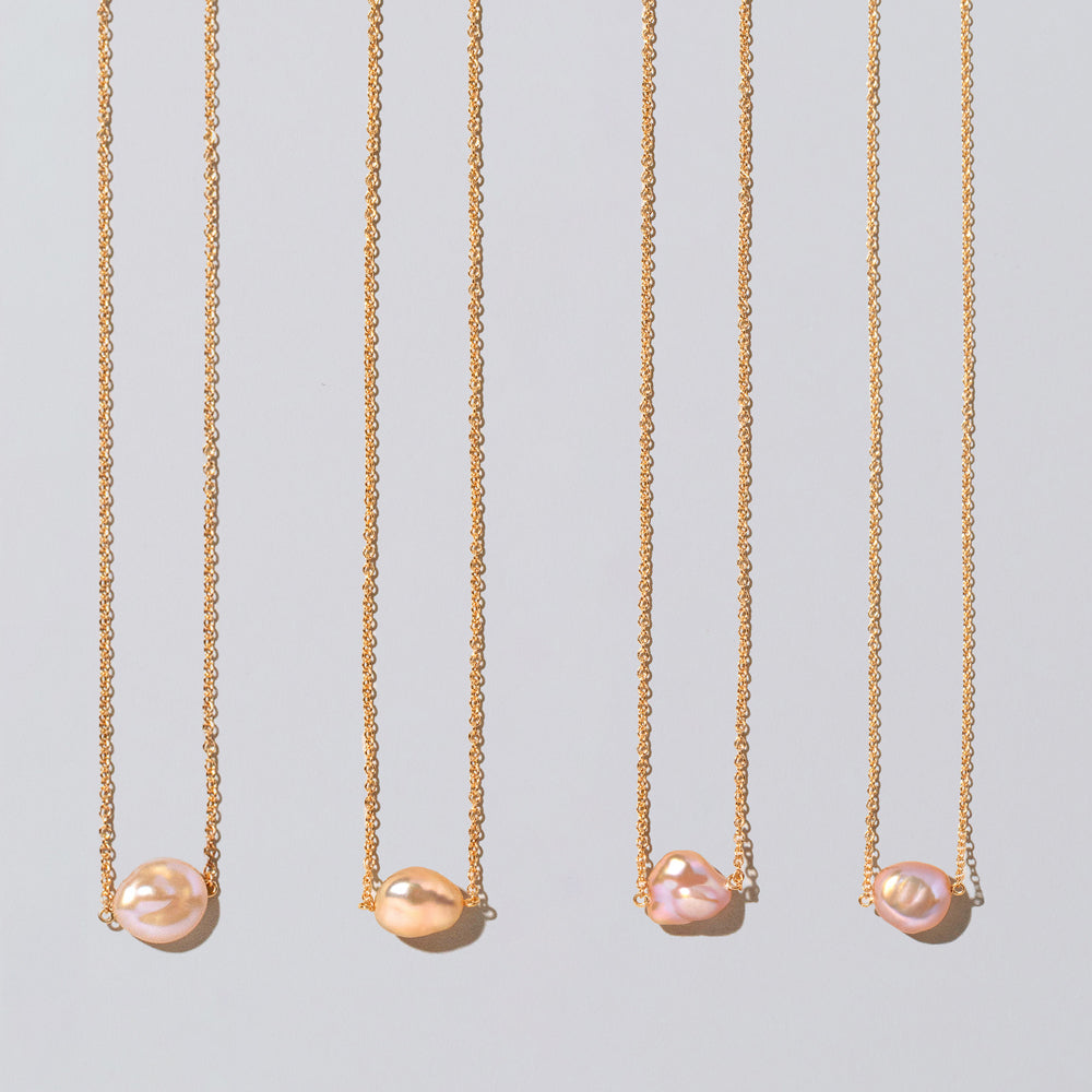 product_details::Closeup details of the Blush Pink Lagniappe Pearl Necklaces on light color background.