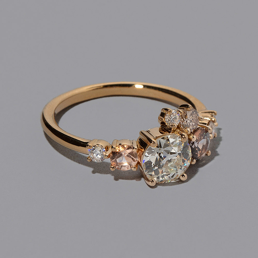 product_details::Closeup details of the Peach Sapphire & Diamonds Luna Ring on light color background.