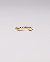 Gold Garnet Single Stone Mini Curve Band on light color background.