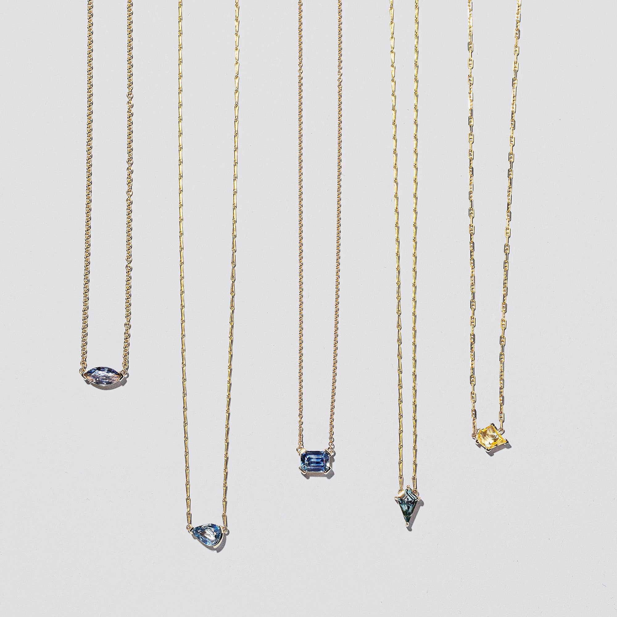 product_details::Group of Gemstone Necklaces on light colored background.
