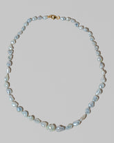 Closeup details of the Ula Pearl Necklace 001 on light color background.