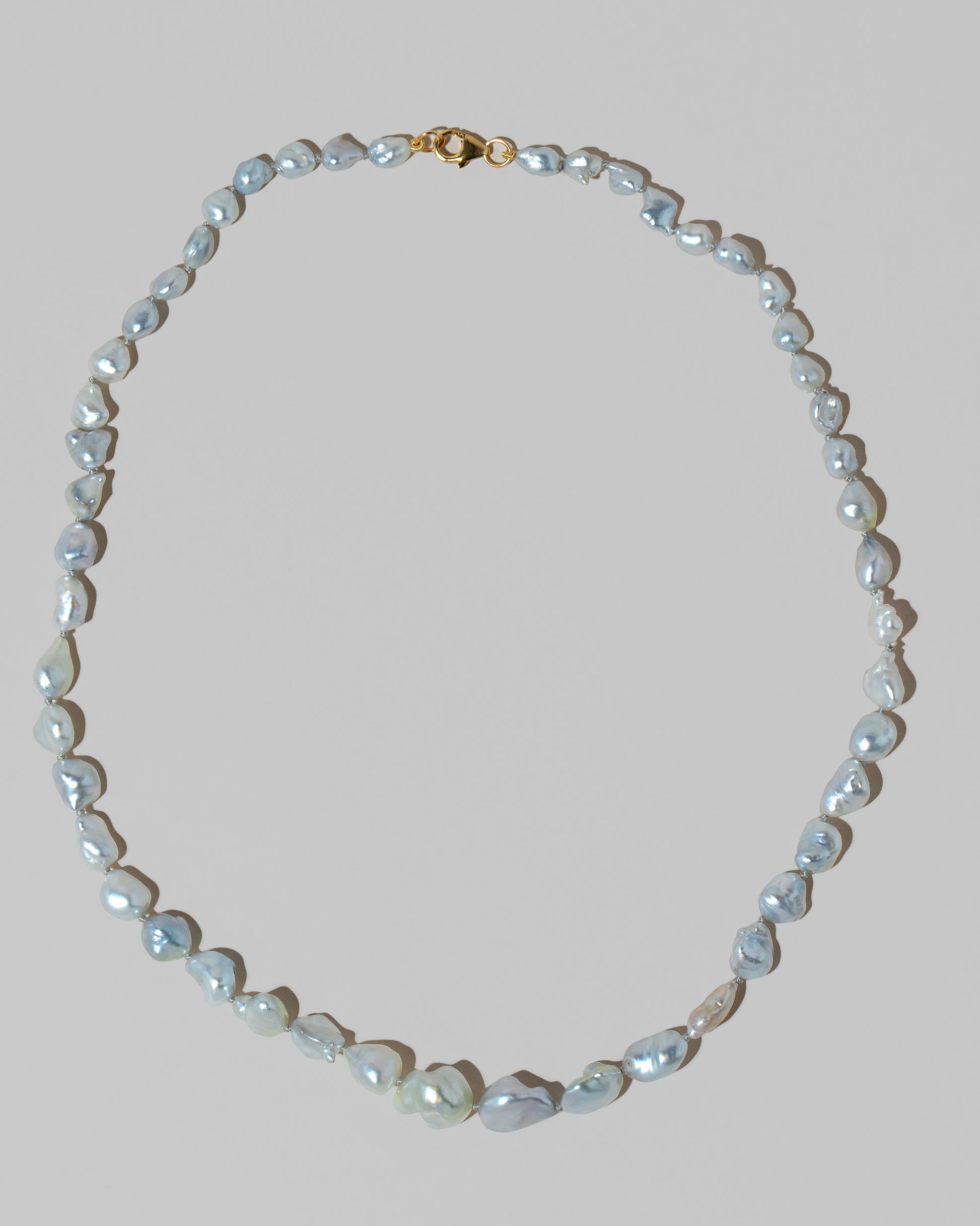 Closeup details of the Ula Pearl Necklace 001 on light color background.