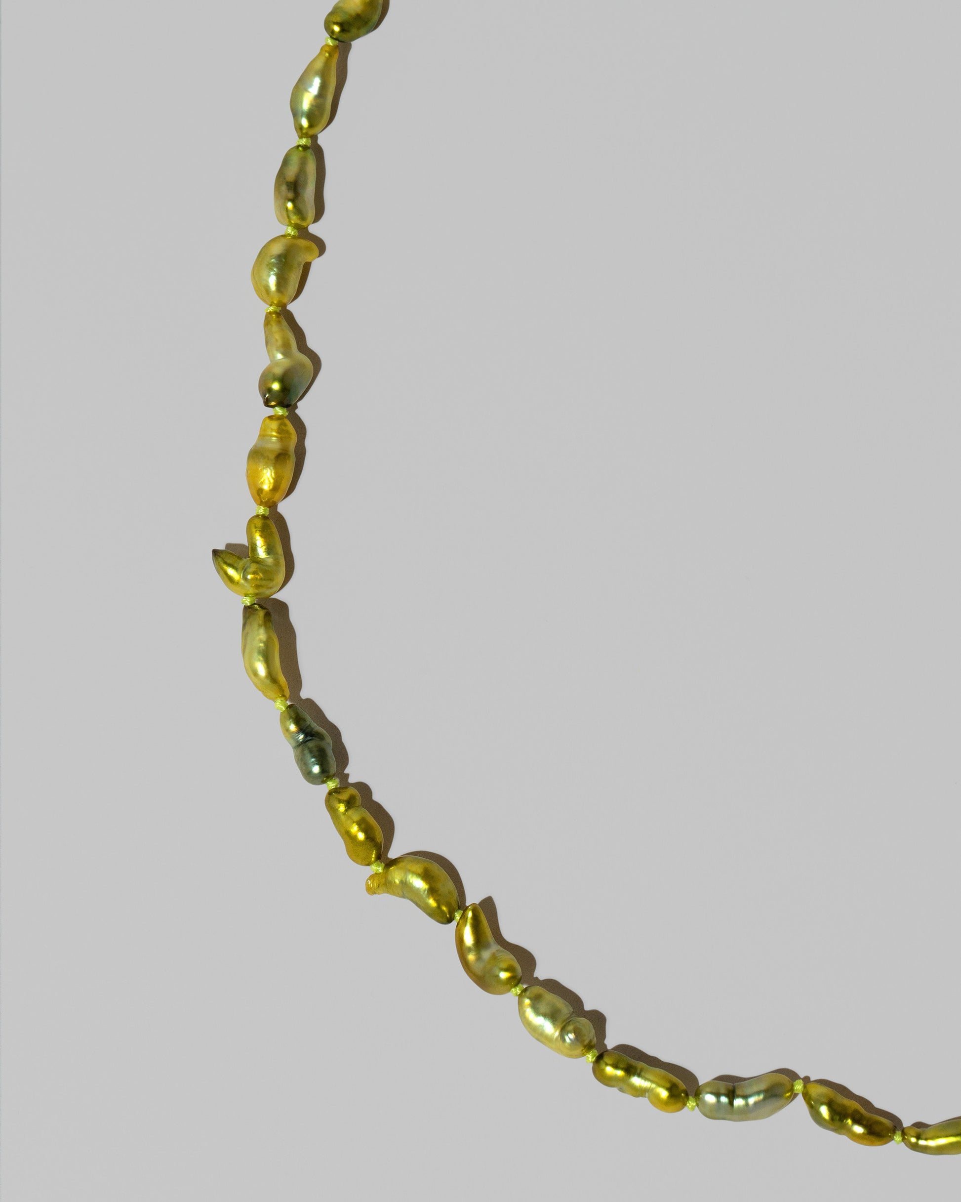 Closeup details of the Ula Pearl Necklace 003 on light color background.