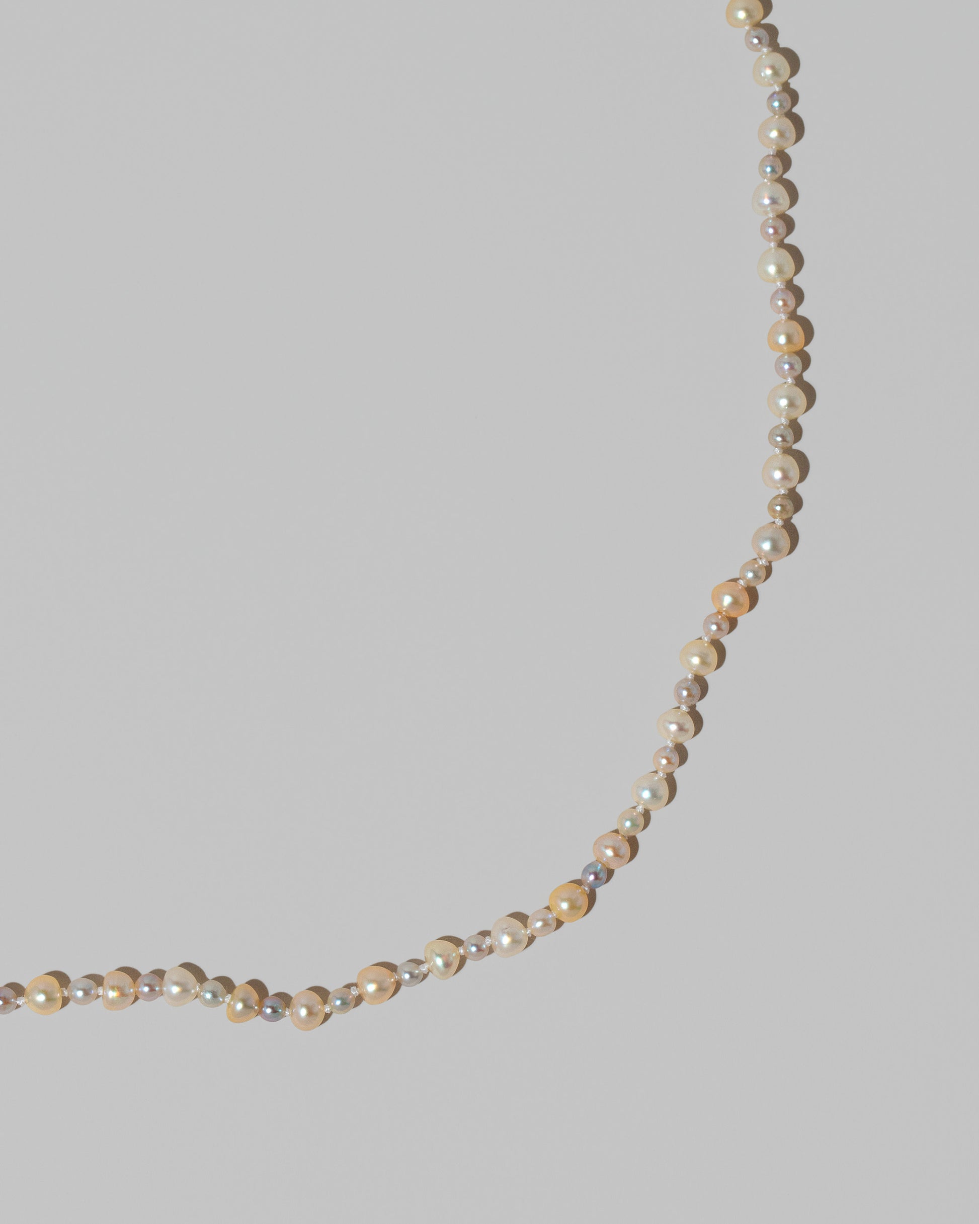 Closeup details of the Ula Pearl Necklace 004 on light color background.