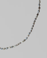 Closeup details of the Ula Pearl Necklace 007 on light color background.