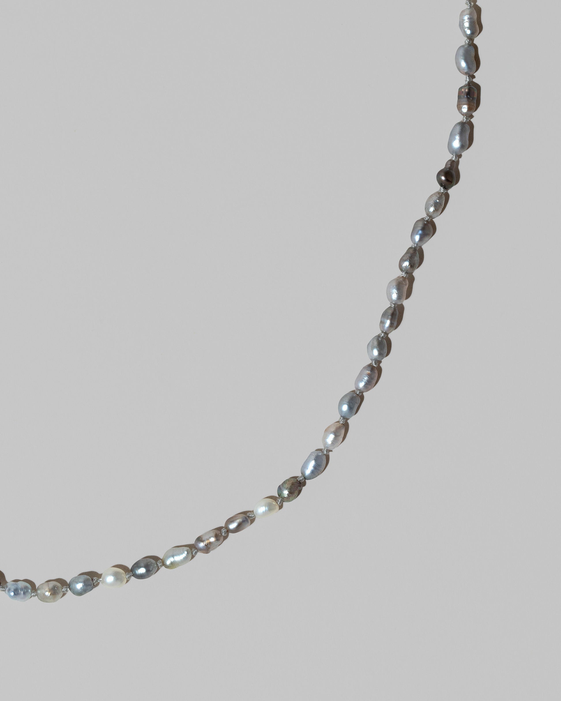 Closeup details of the Ula Pearl Necklace 007 on light color background.