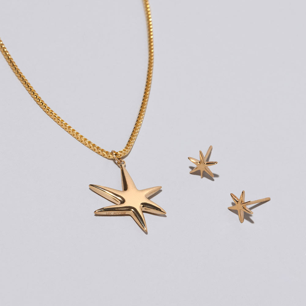 product_details::Gold Stars Necklace & Studs Set on light color background.