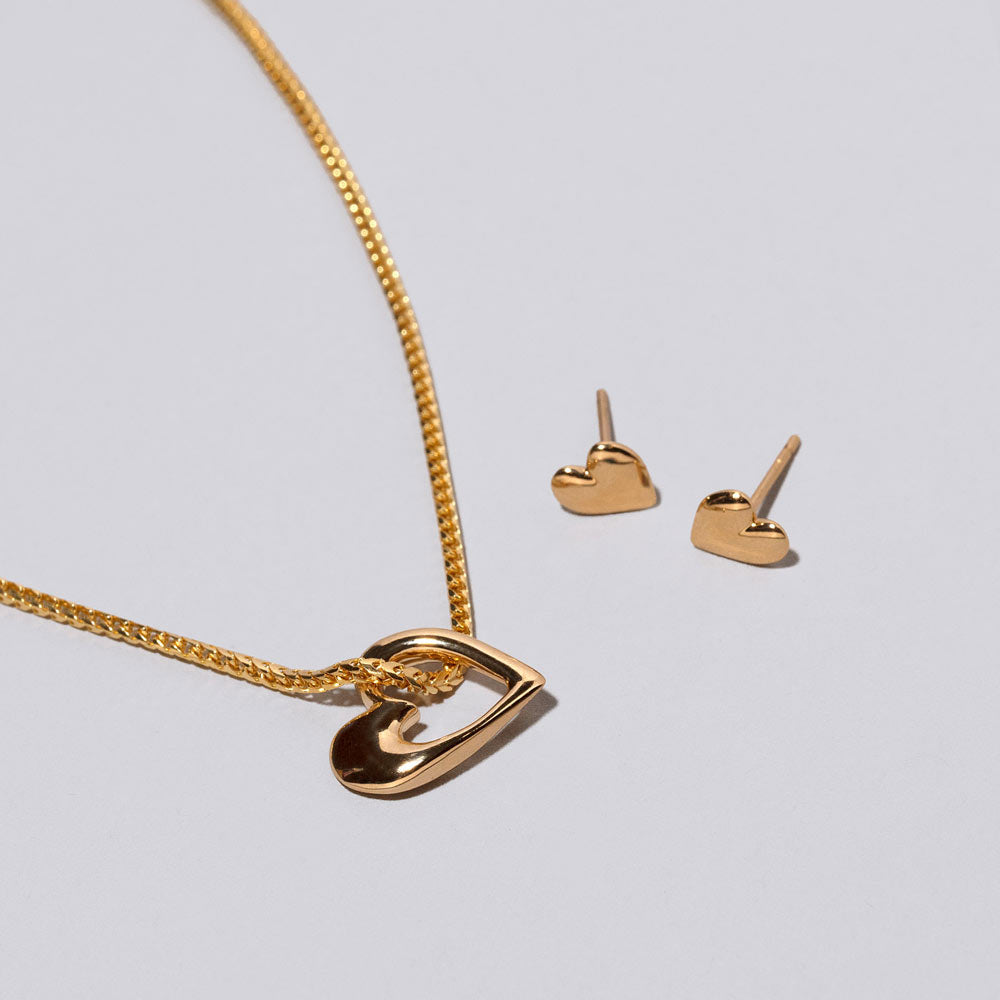 product_details::Gold Hearts Necklace & Studs Set on light color bckground.