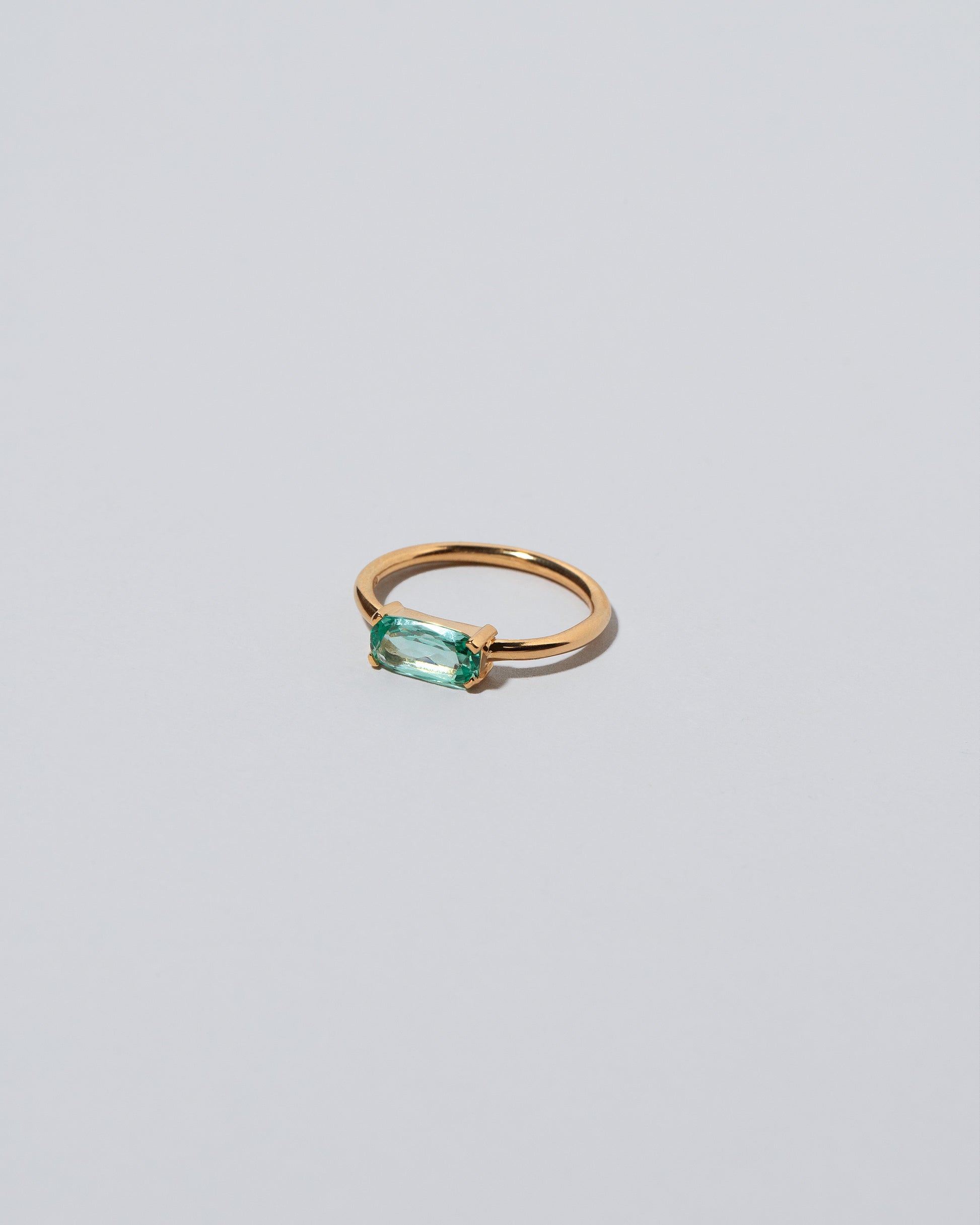 Green Adage Ring on light color background.