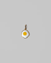 Fried Egg Pendant on light color background.