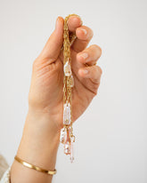 Birthstone Pearl Pendants styled with the 3mm Beveled Oval Chain Necklace, Hot Dog Chain Necklace and 2.4mm Curb Chain Necklaces in hand on model.