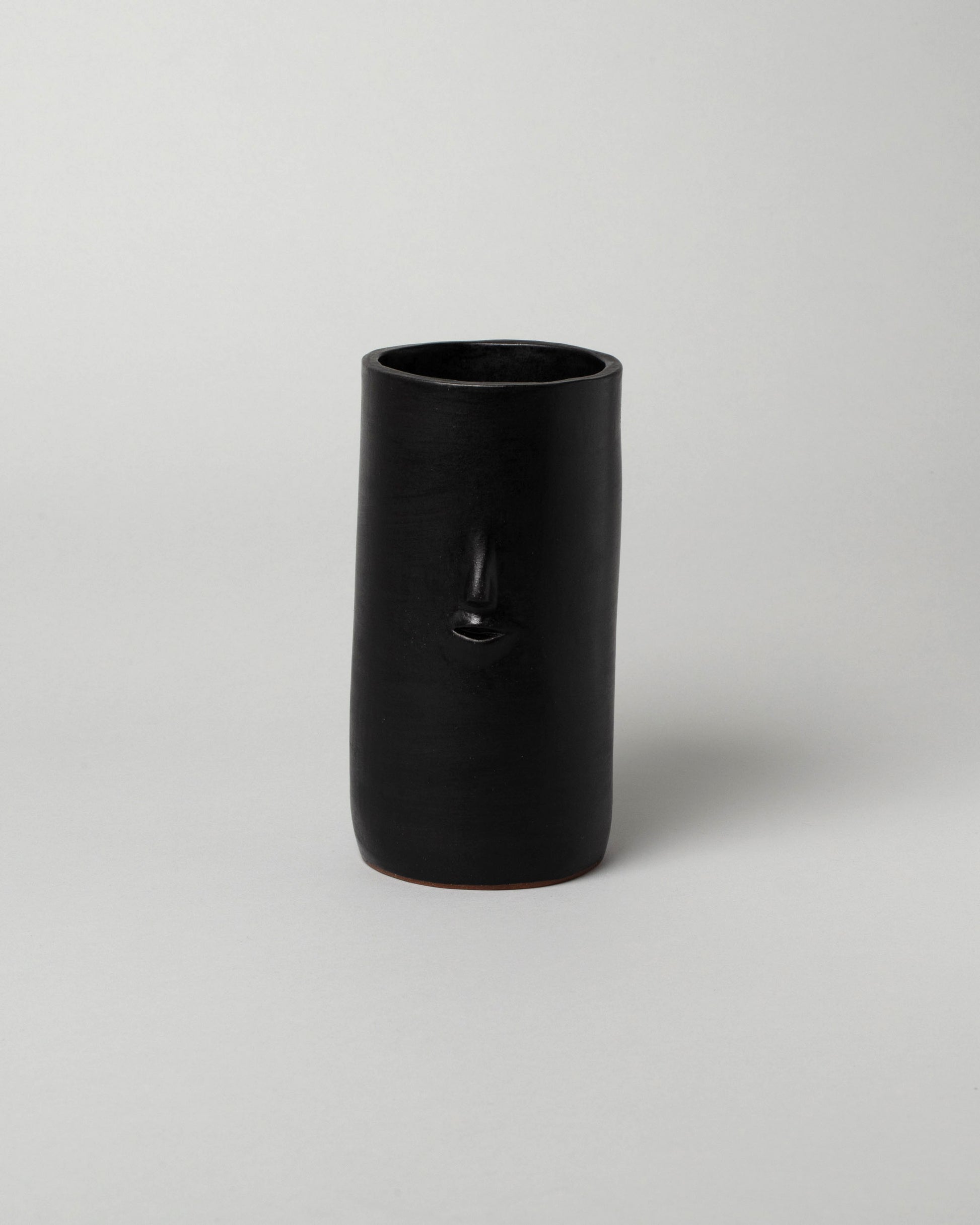 Rami Kim Matte Black Face Vase on light color background.