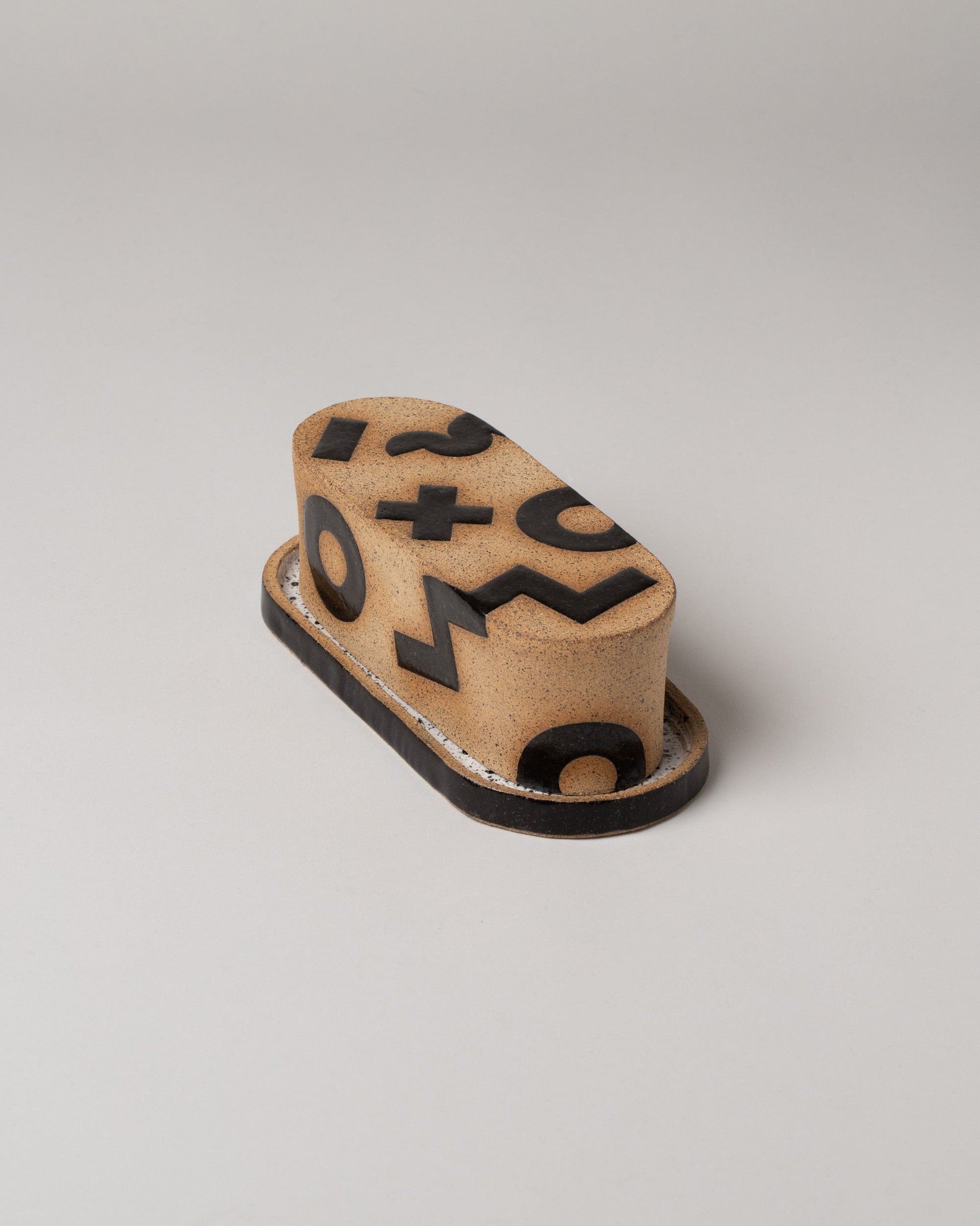Tan Positive Shapes Butter Dish on light color background.