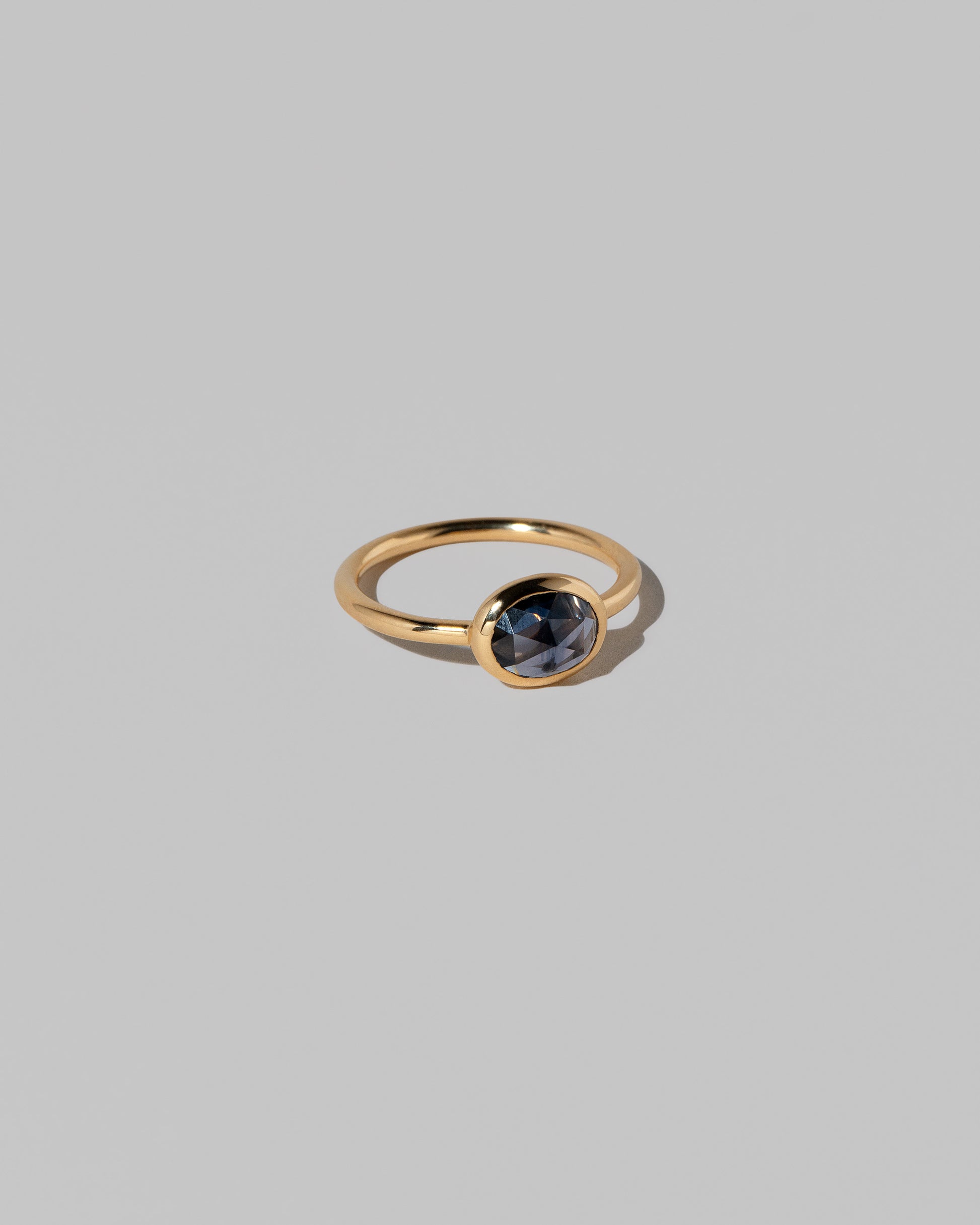 View from the side of the Gusher Blue Sapphire Ring 022 on light color background.