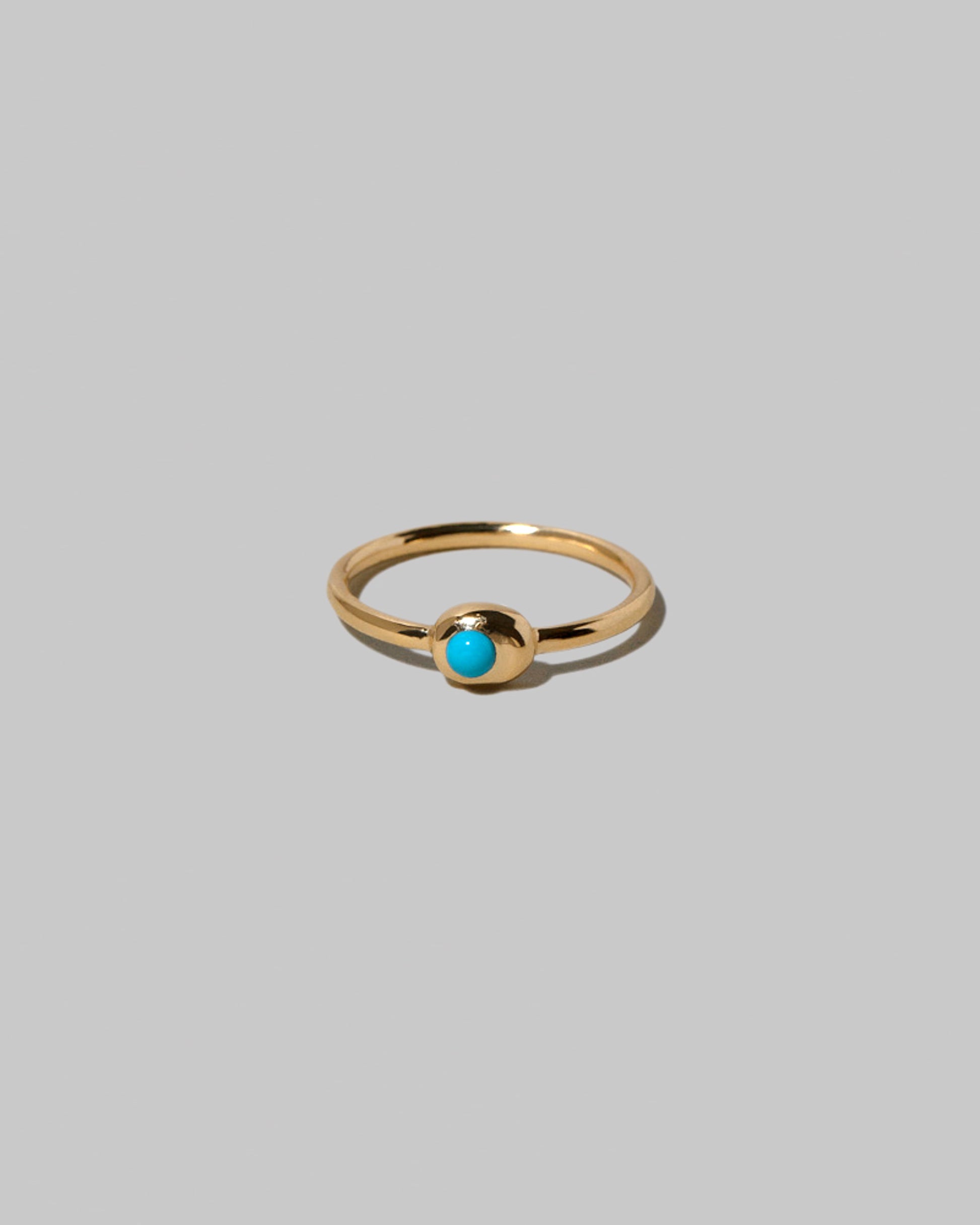 Turquoise Cabochon Birthstone Level Ring on light color background.