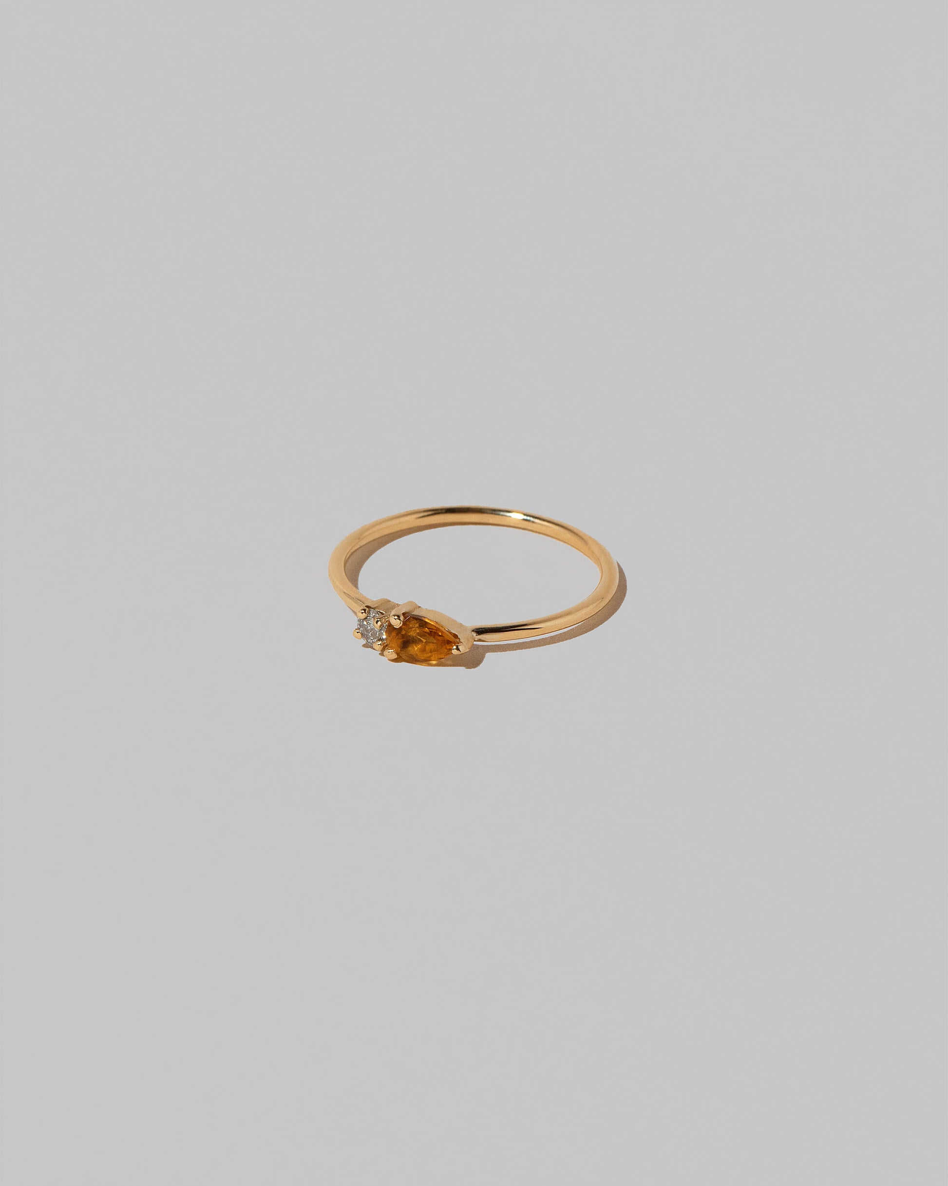 View from the side of the Citrine Teardrops Ring on light color background.