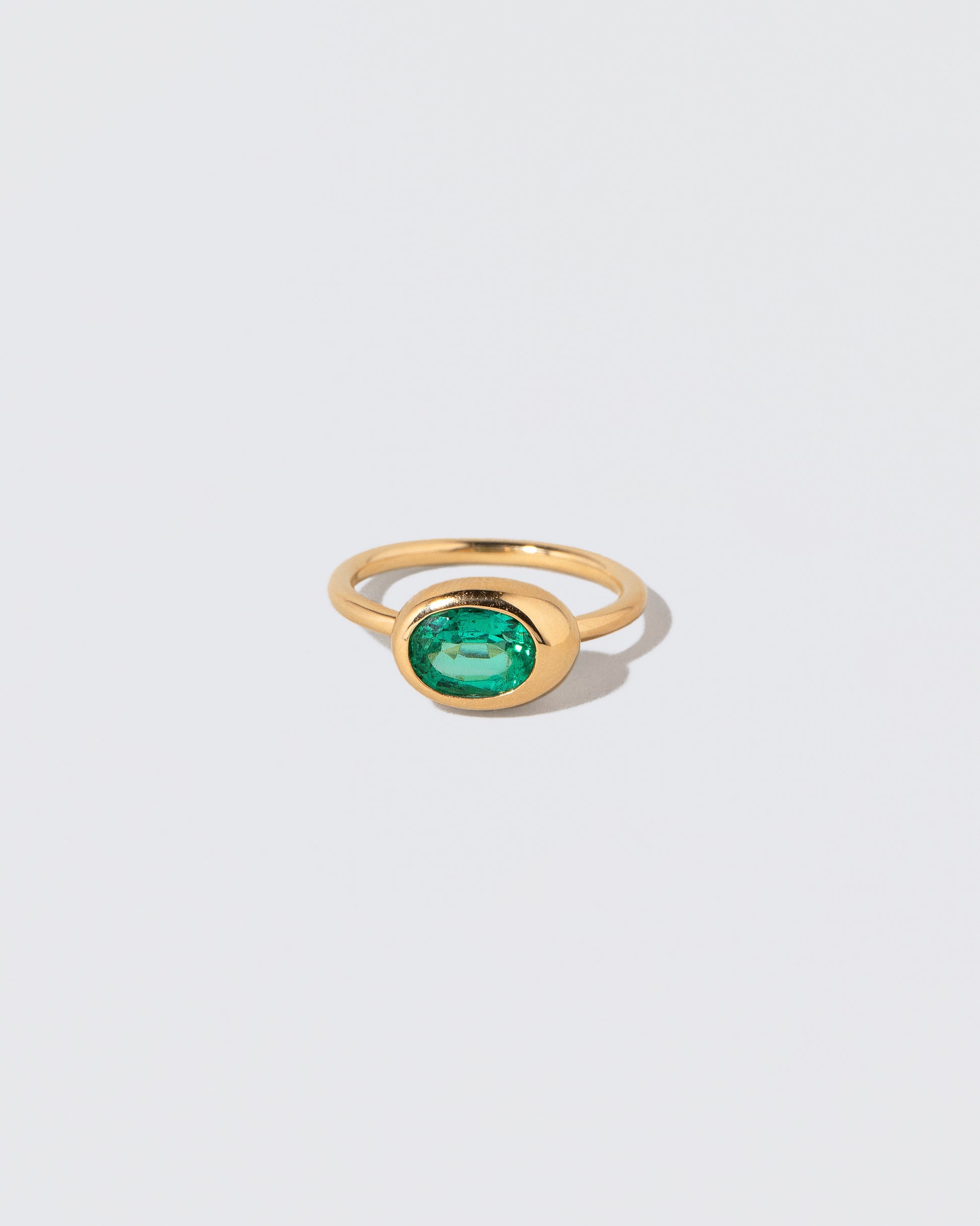 Oval Emerald Equalize Ring on light color background.