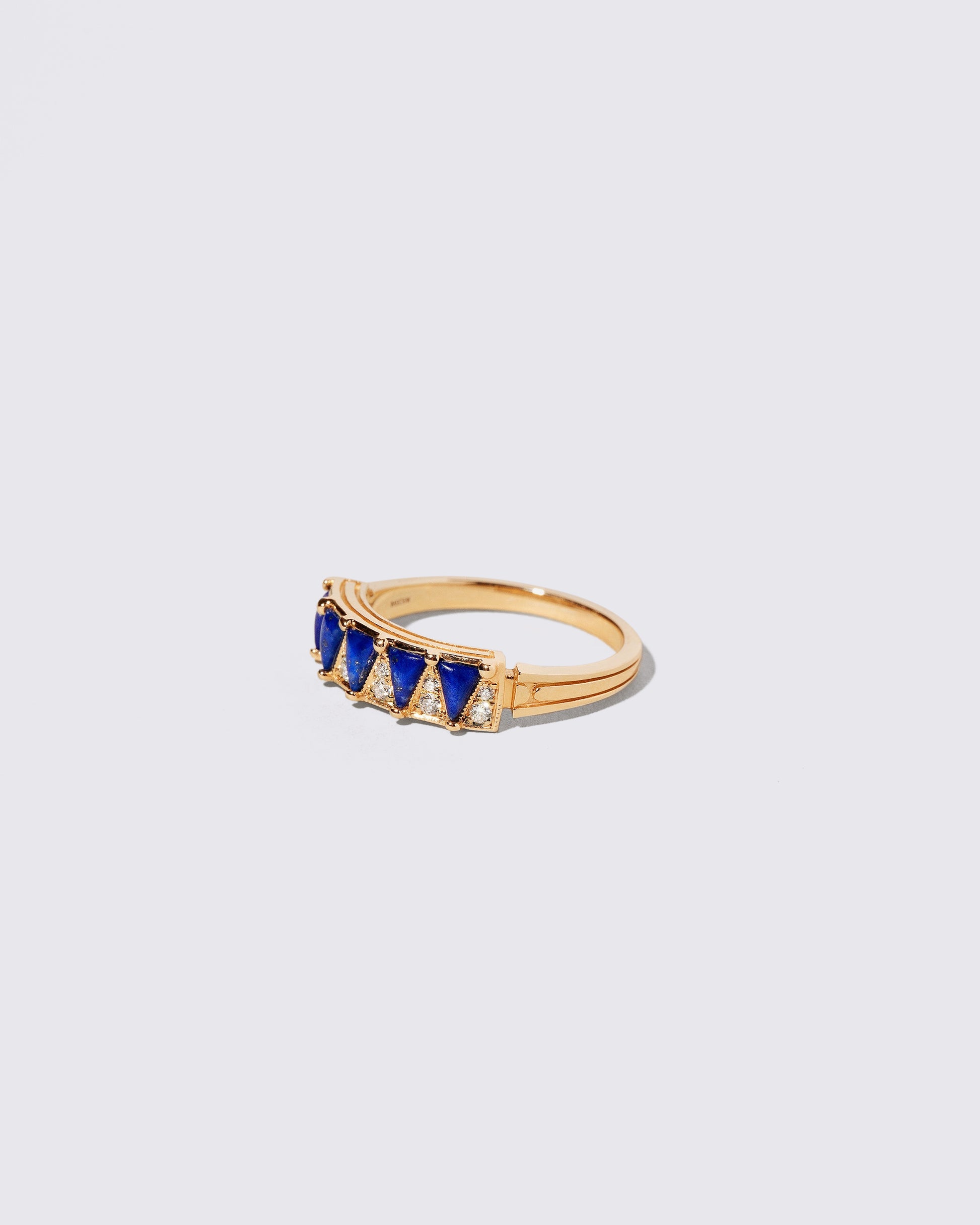 View from the side of the Gold Lapis Five Triangle Ring on light color background.