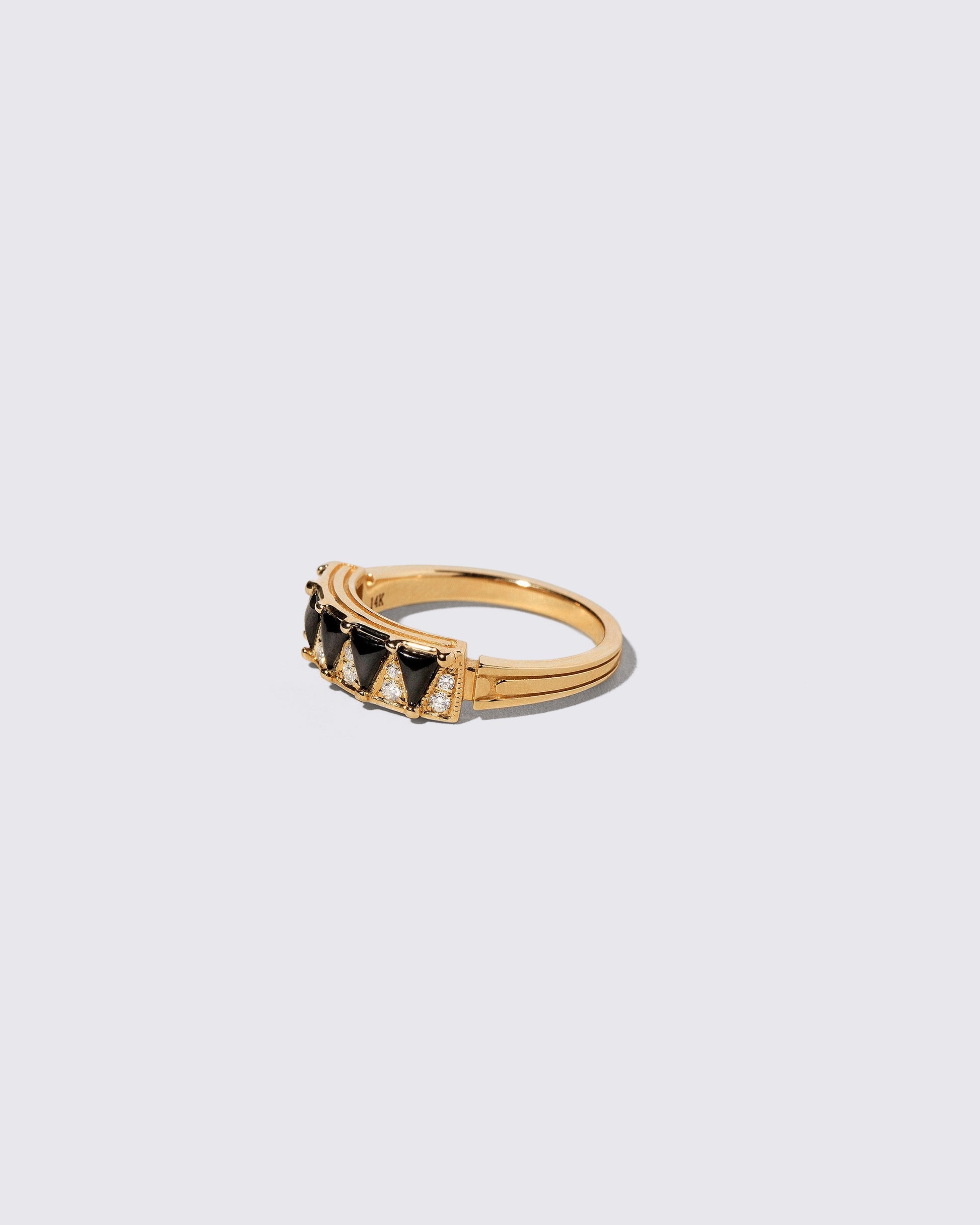 View from the side of the Gold Black Spinel Five Triangle Ring on light color background.