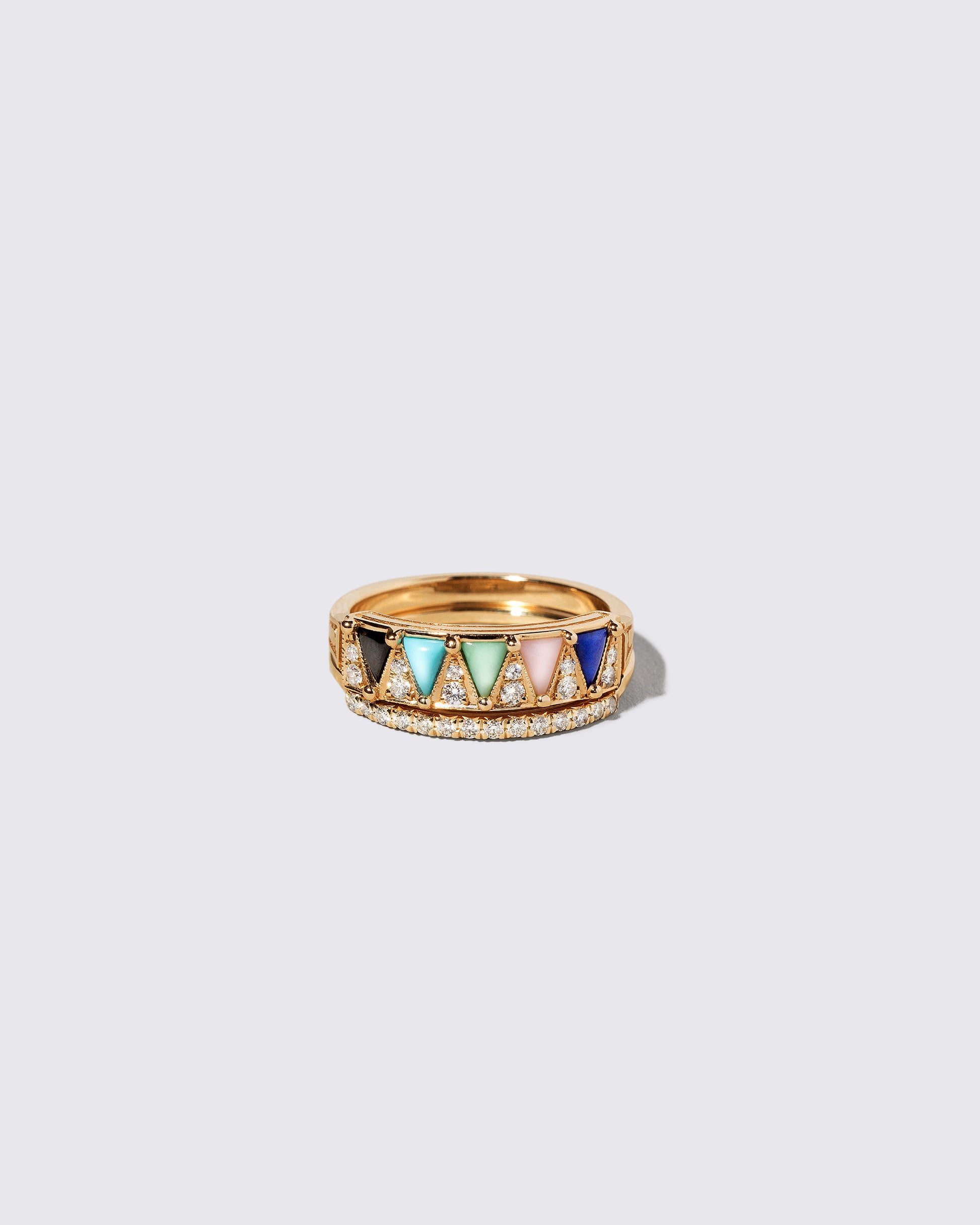 Gold Notched Band and Gold Mega Five Triangle Ring on light color background.