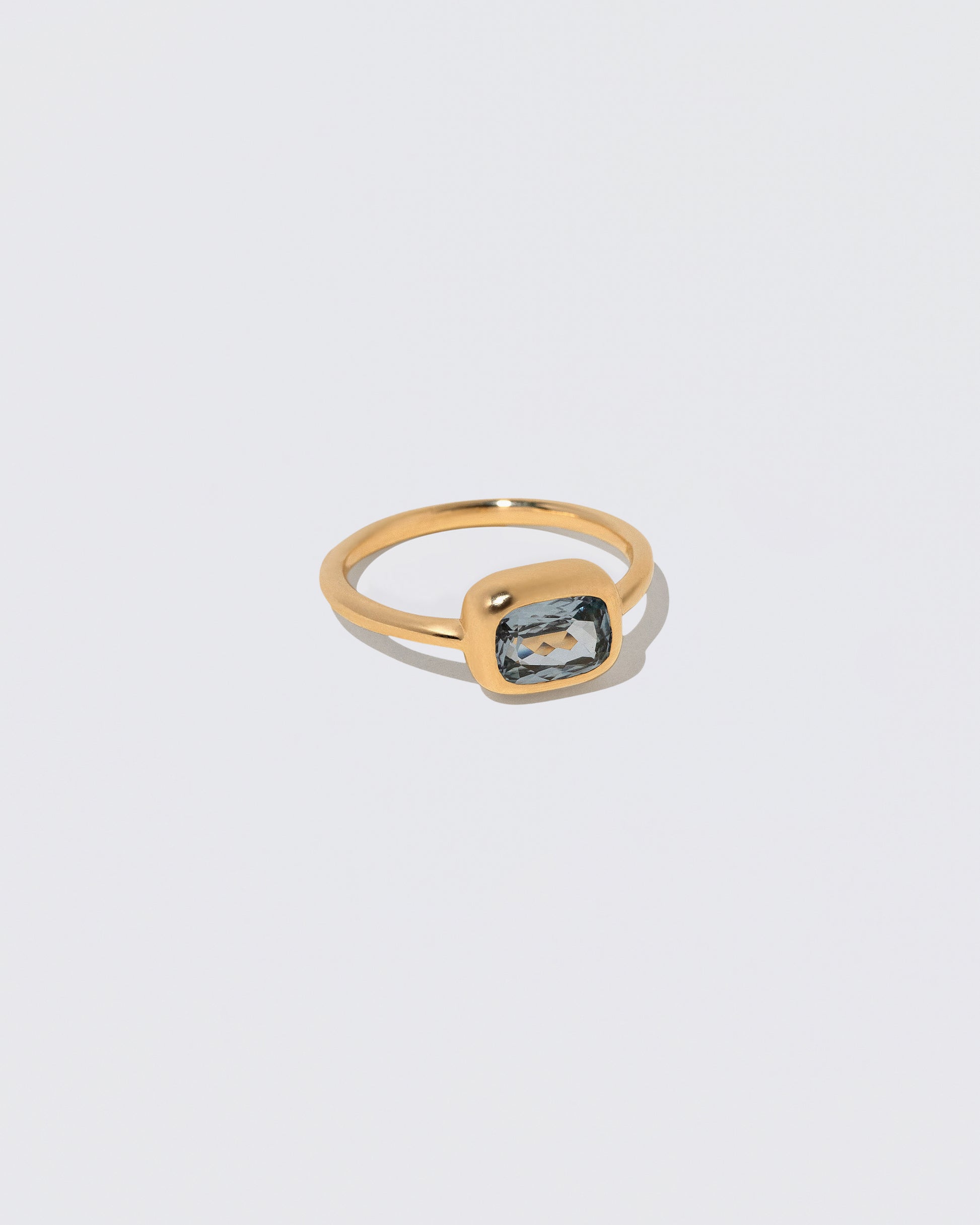View from the side of the Geyser Light Blue Sapphire Ring 007 on light color background.