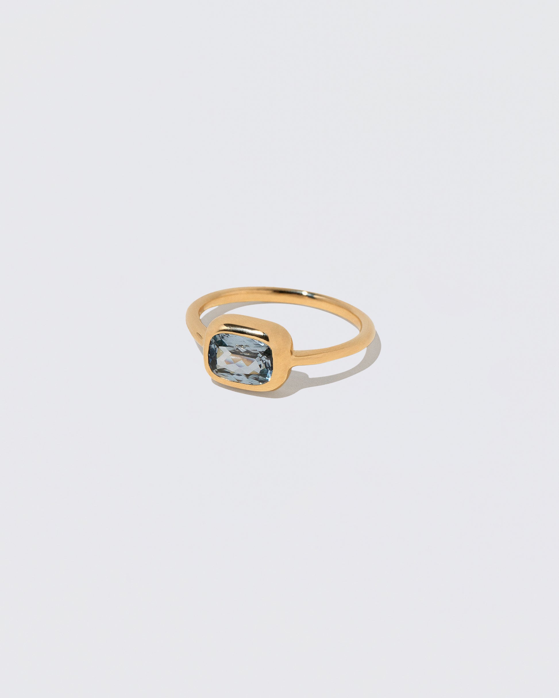 View from the side of the Geyser Light Blue Sapphire Ring 007 on light color background.