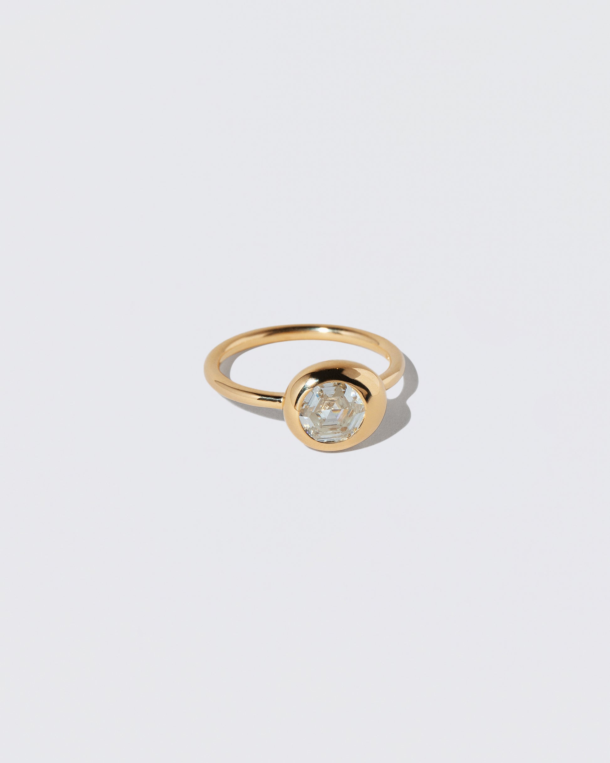 View from the side of the Step Cut Diamond Grand Level Ring on light color background.
