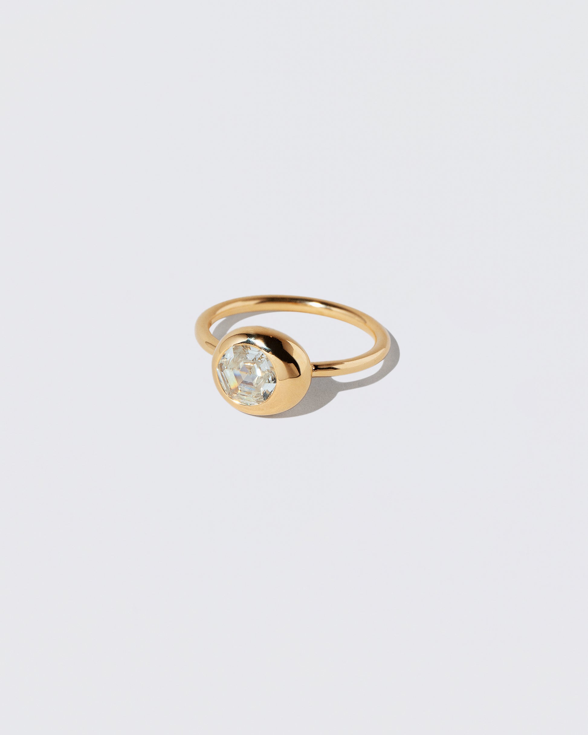 View from the side of the Step Cut Diamond Grand Level Ring on light color background.