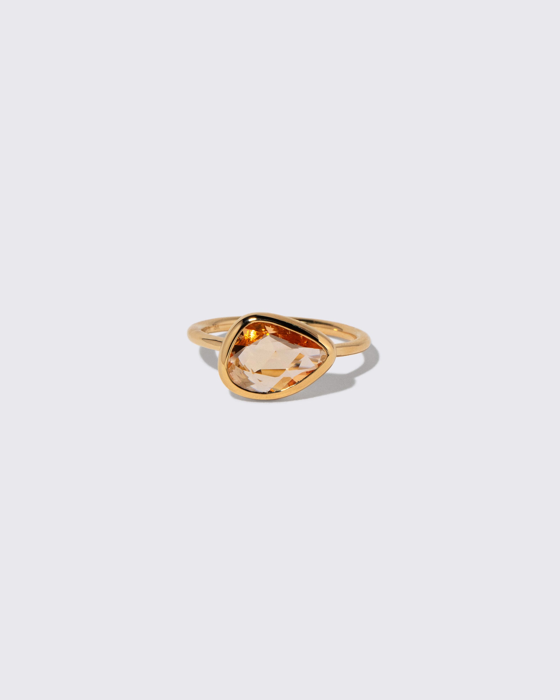 Peach Pink Sapphire Gusher Ring on light color background.