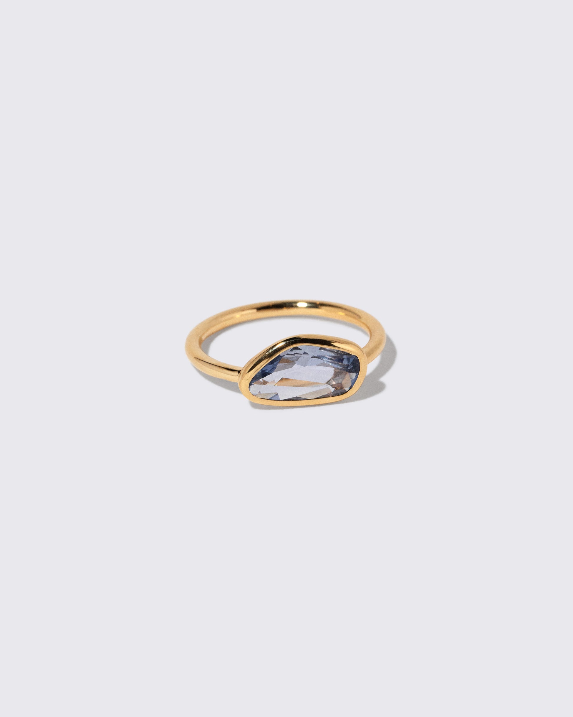 View from the side of the Blue Sapphire Gusher Ring on light color background.