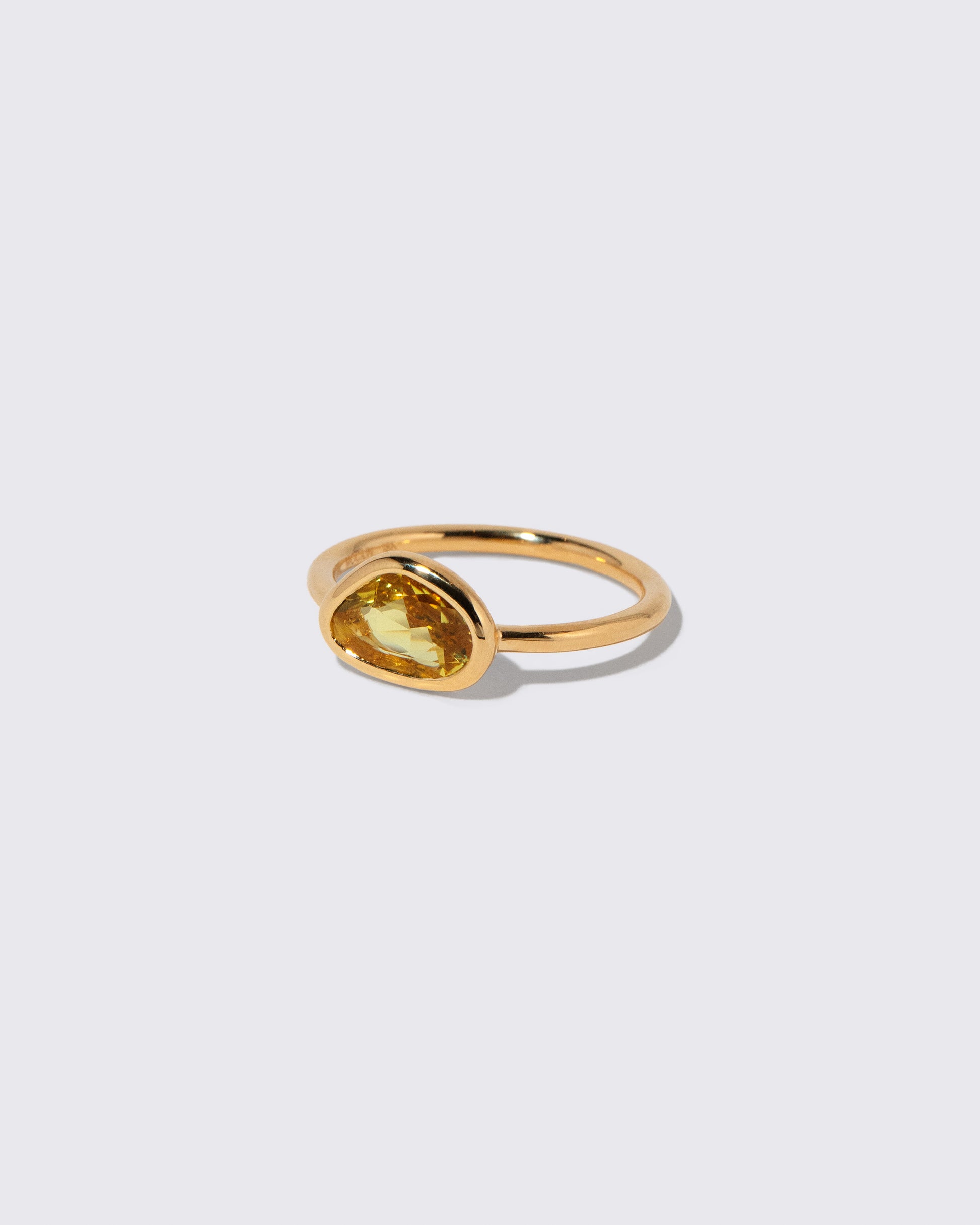 View from the side of the Yellow Sapphire Gusher Ring on light color background.