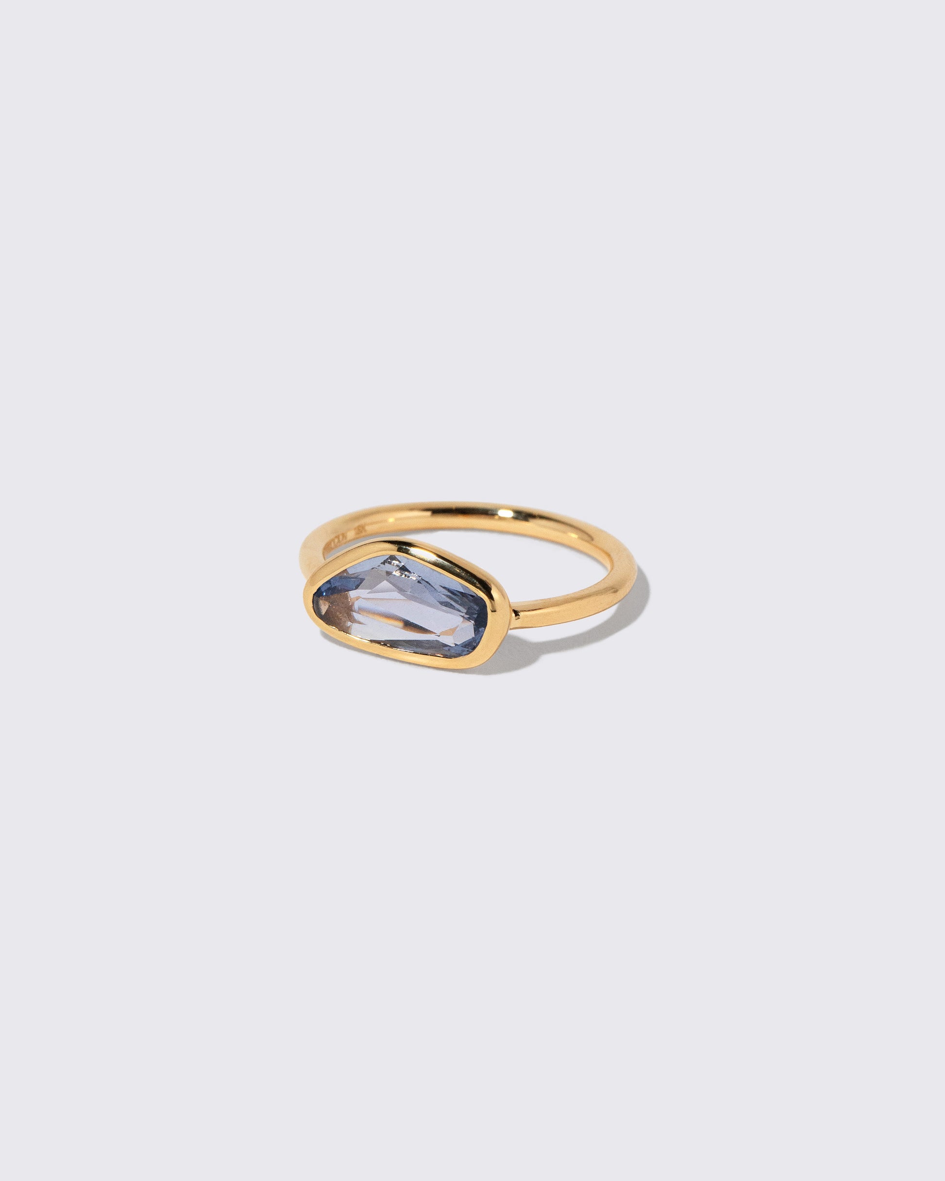 View from the side of the Blue Sapphire Gusher Ring on light color background.