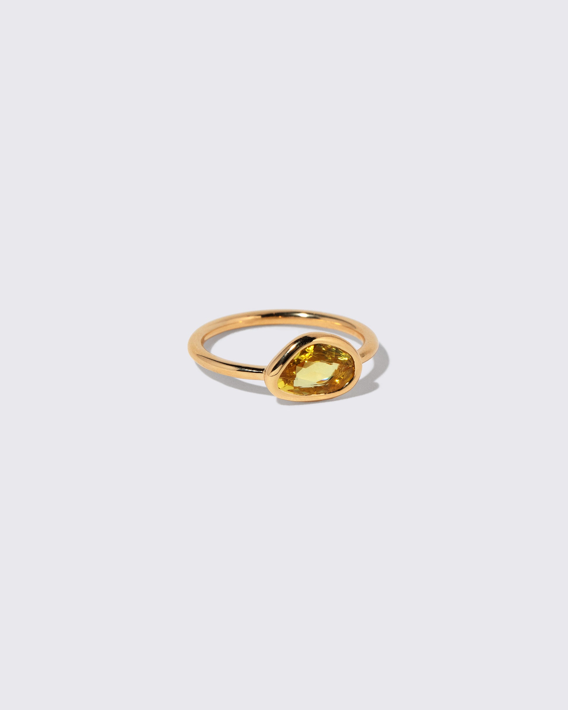 View from the side of the Yellow Sapphire Gusher Ring on light color background.
