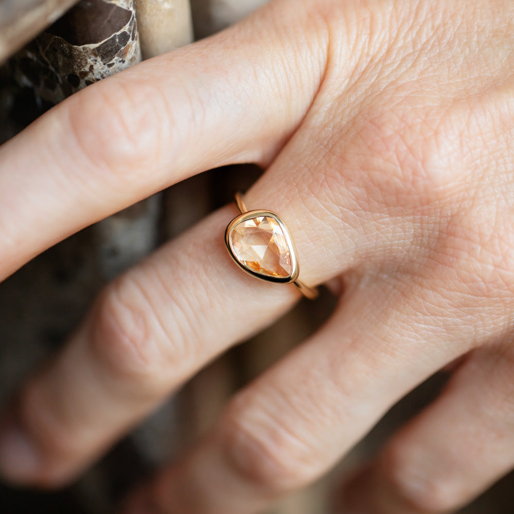 product_details::Peach Pink Sapphire Gusher Ring on model.