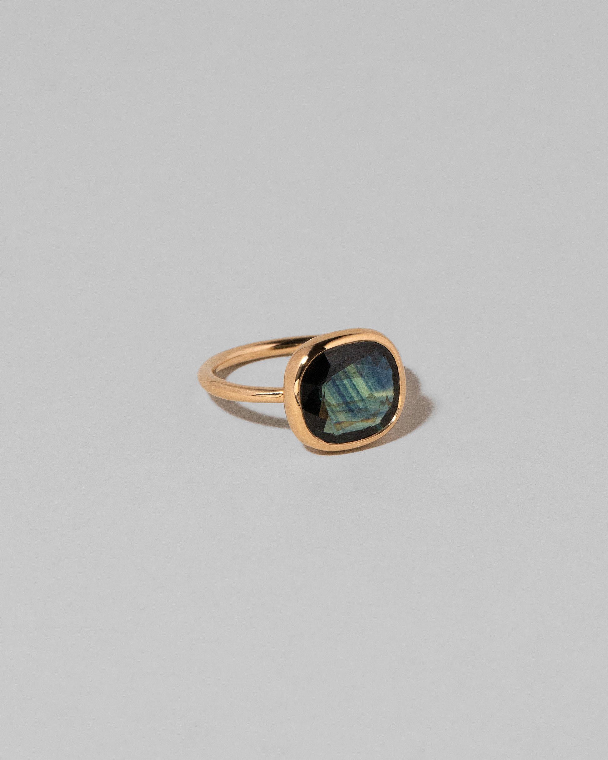 View from the side of the Gusher Bicolor Sapphire Ring 012 on light color background.