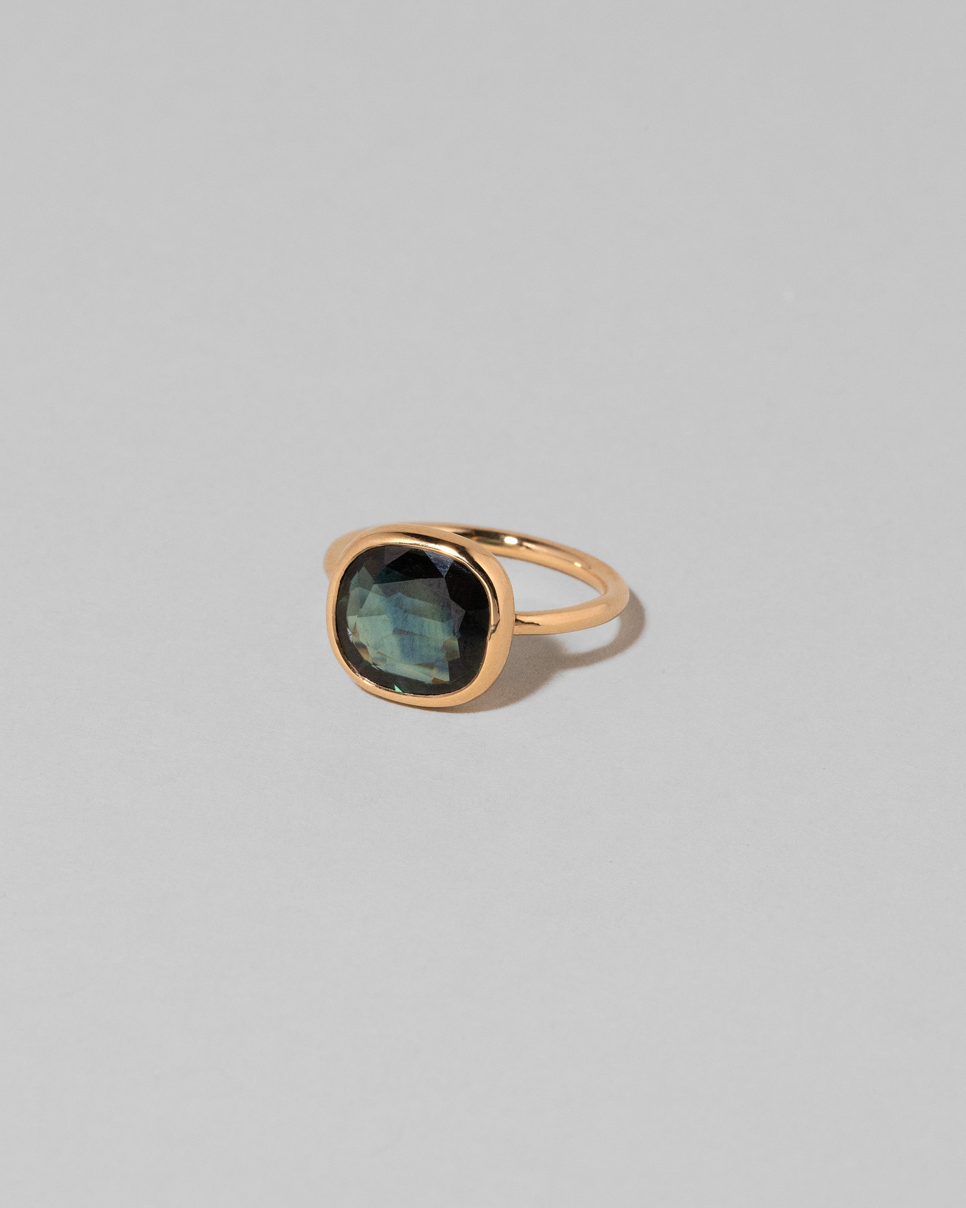 View from the side of the Gusher Bicolor Sapphire Ring 012 on light color background.