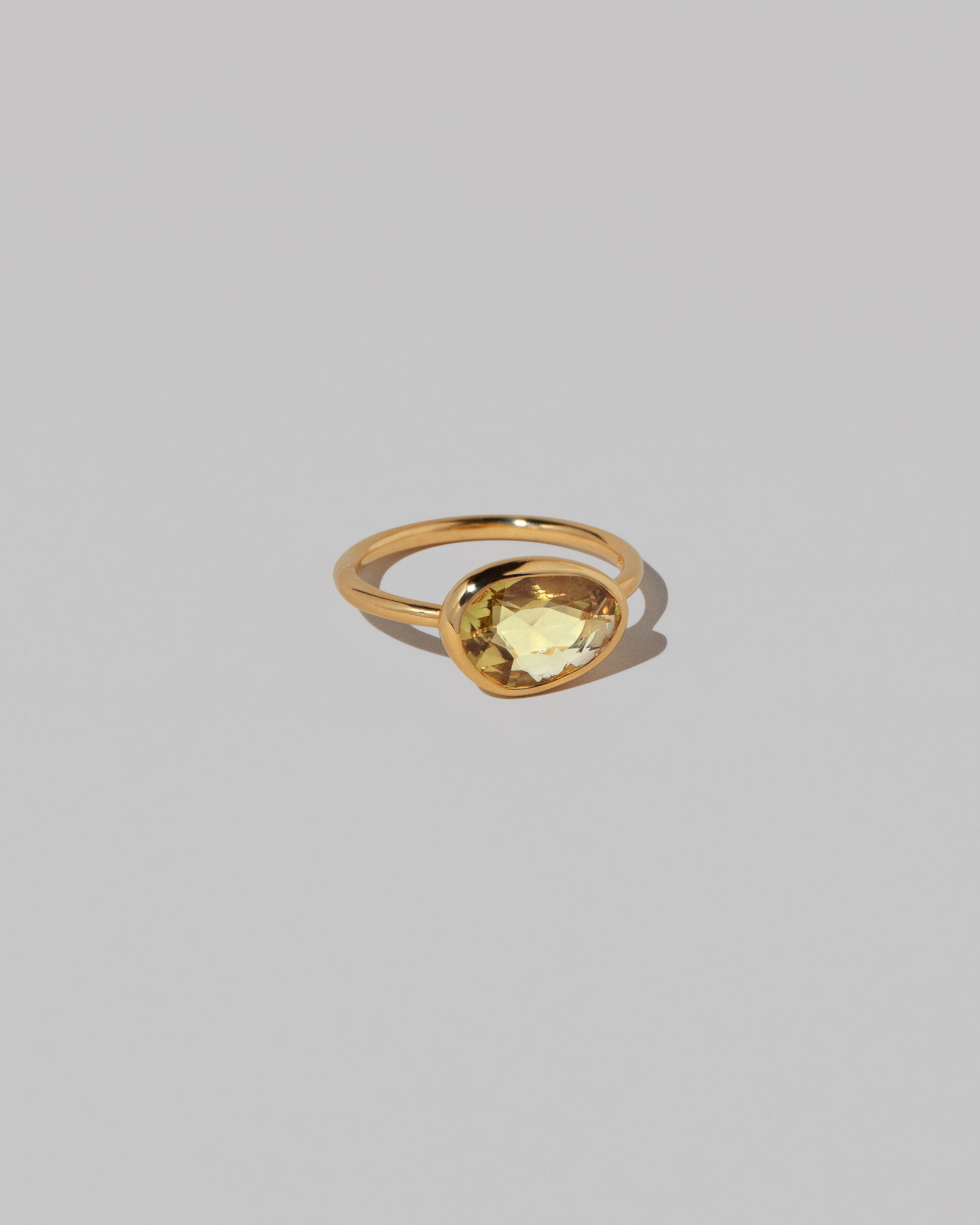 View from the side of the Gusher Yellow Sapphire Ring 033 on light color background.