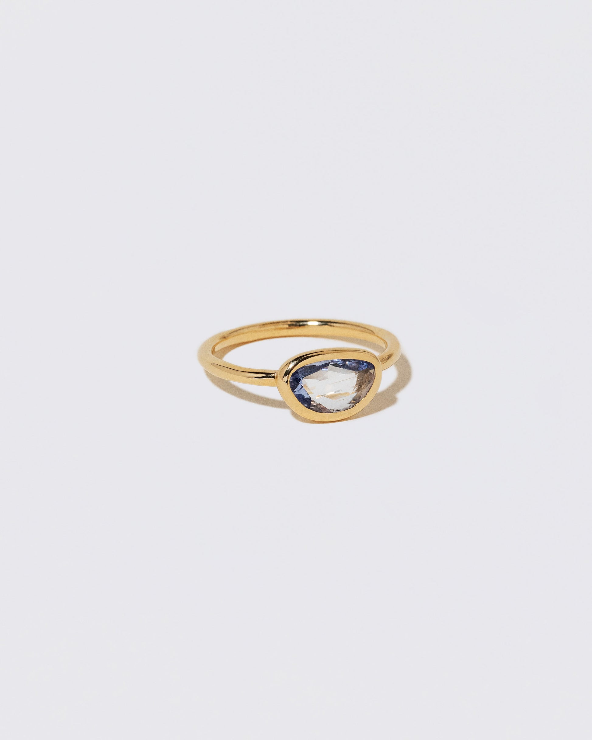 View from the side of the Gusher Blue Sapphire Ring 055 on light color background.