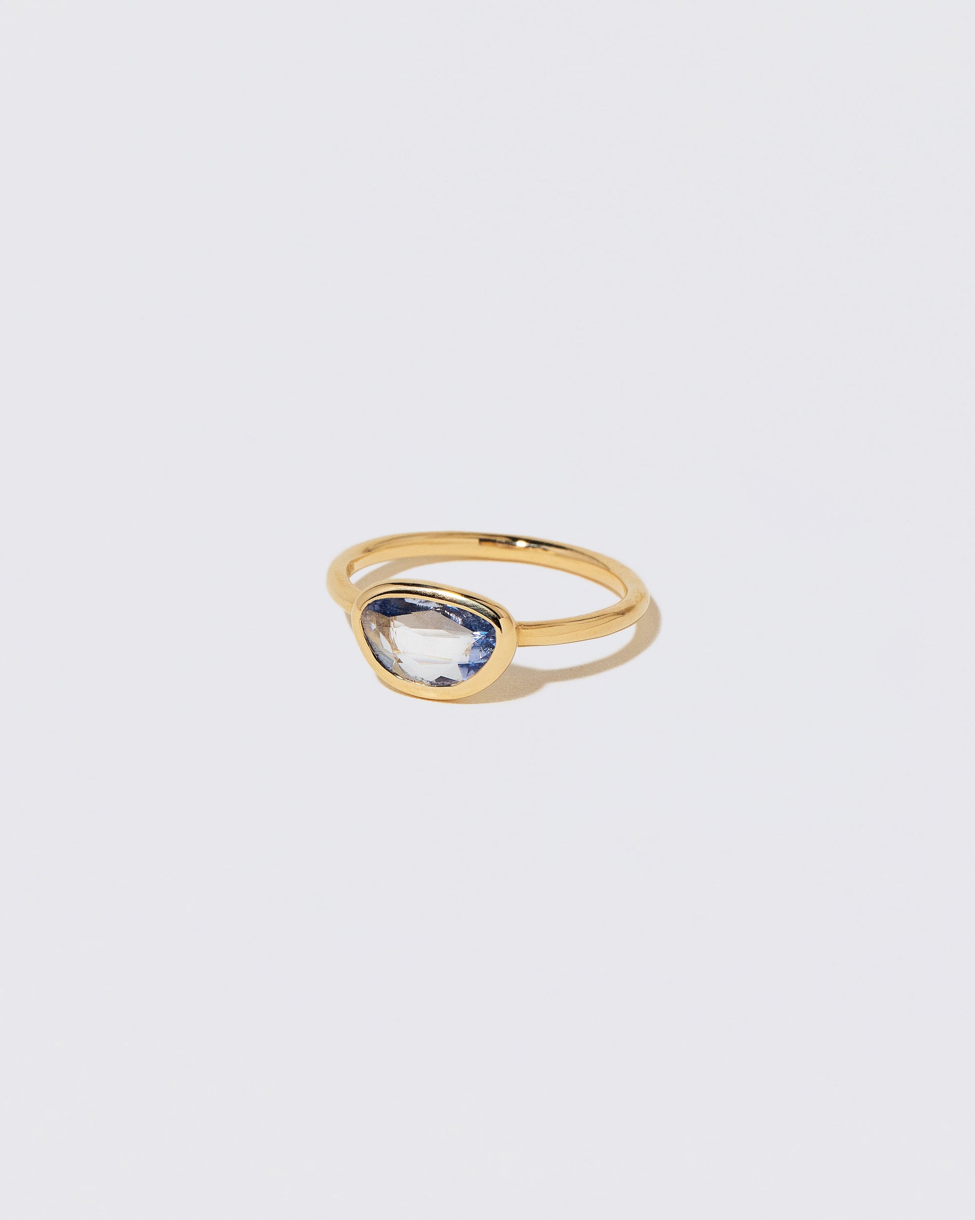 View from the side of the Gusher Blue Sapphire Ring 055 on light color background.