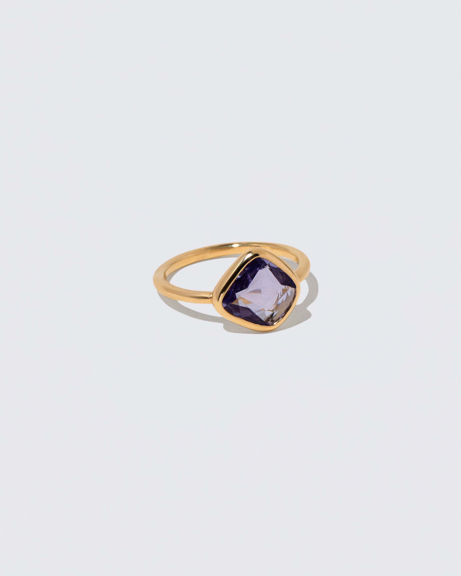 View from the side of the Gusher Purple Sapphire Ring 054 on light color background.