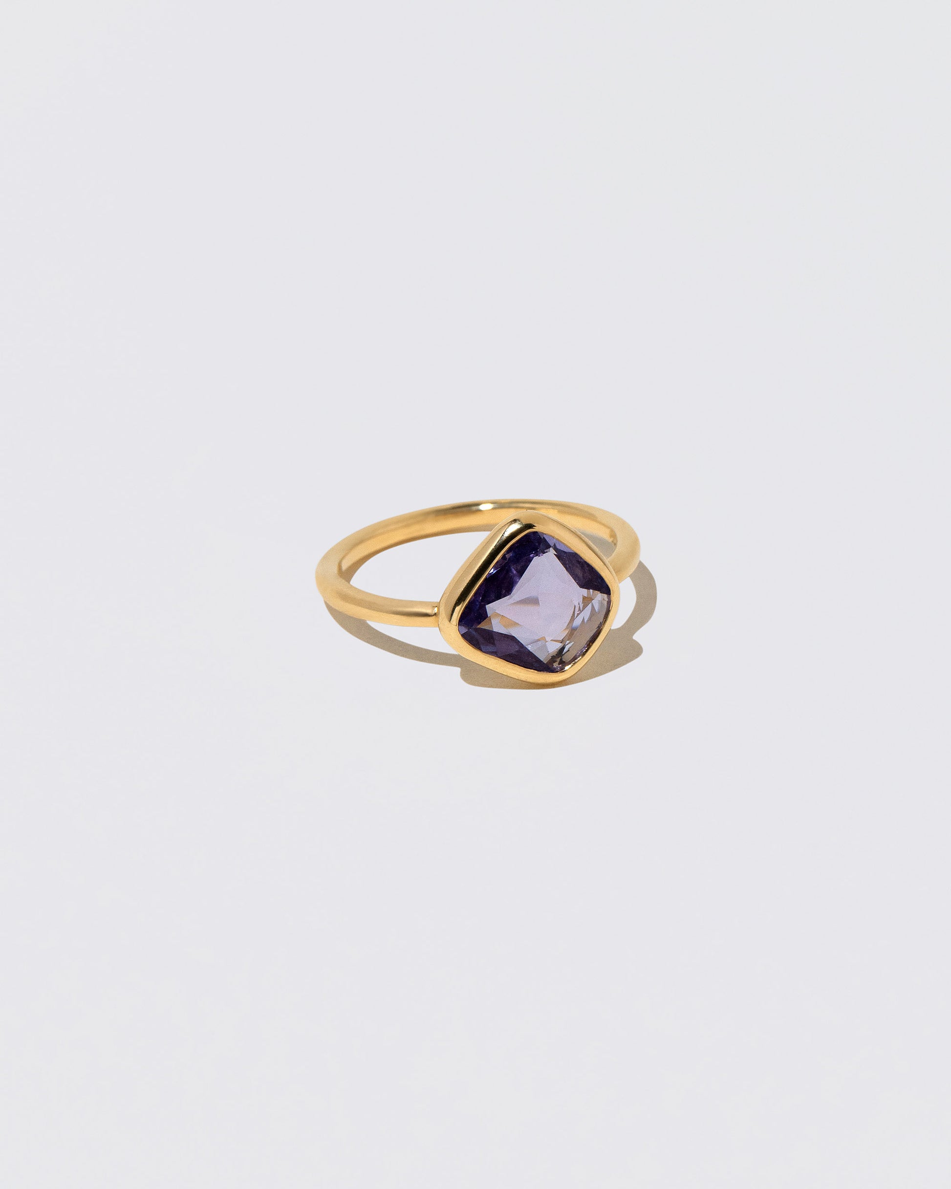 View from the side of the Gusher Purple Sapphire Ring 054 on light color background.