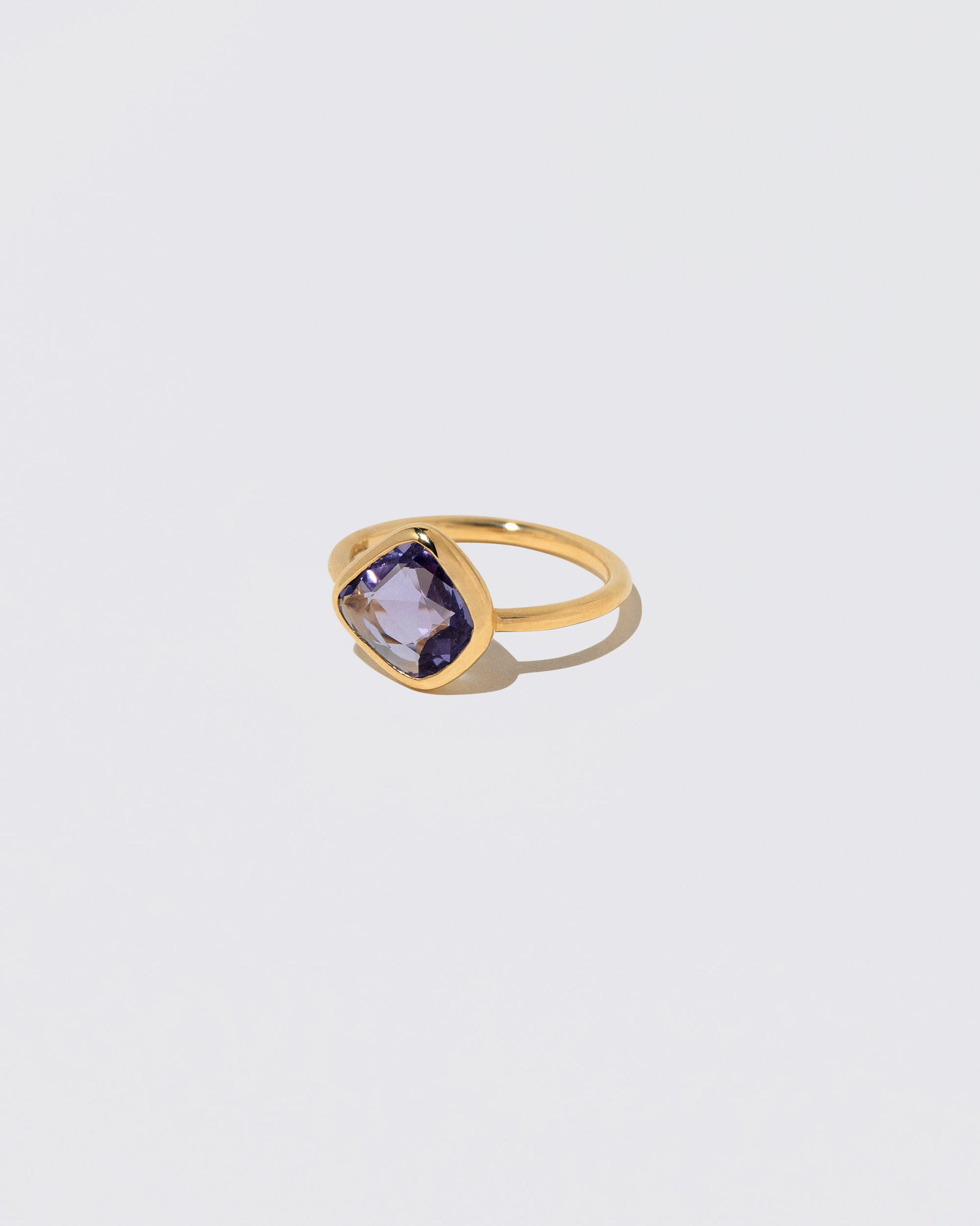 View from the side of the Gusher Purple Sapphire Ring 054 on light color background.