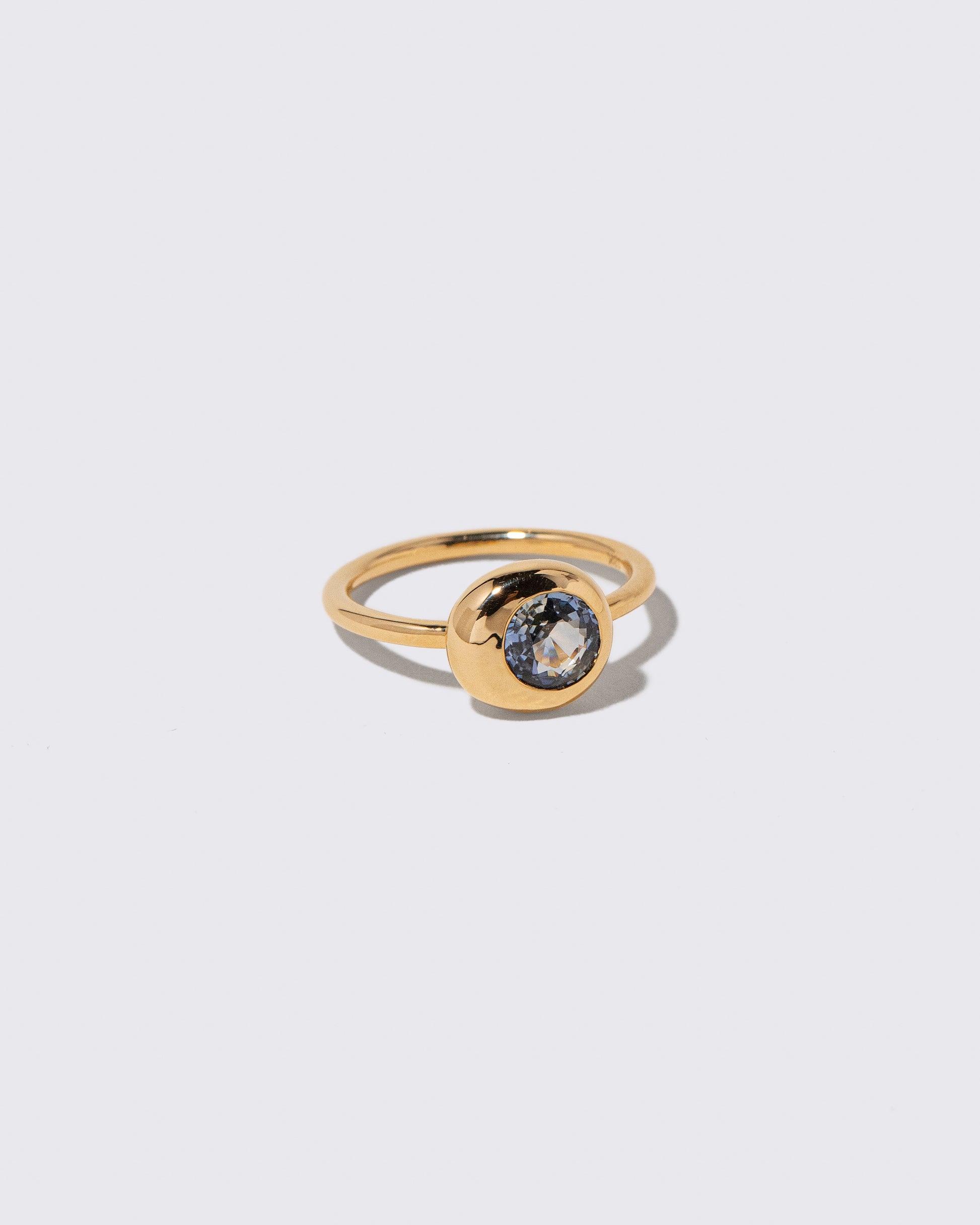 View from the side of the Bicolor Blue Sapphire Level Ring on light color background.